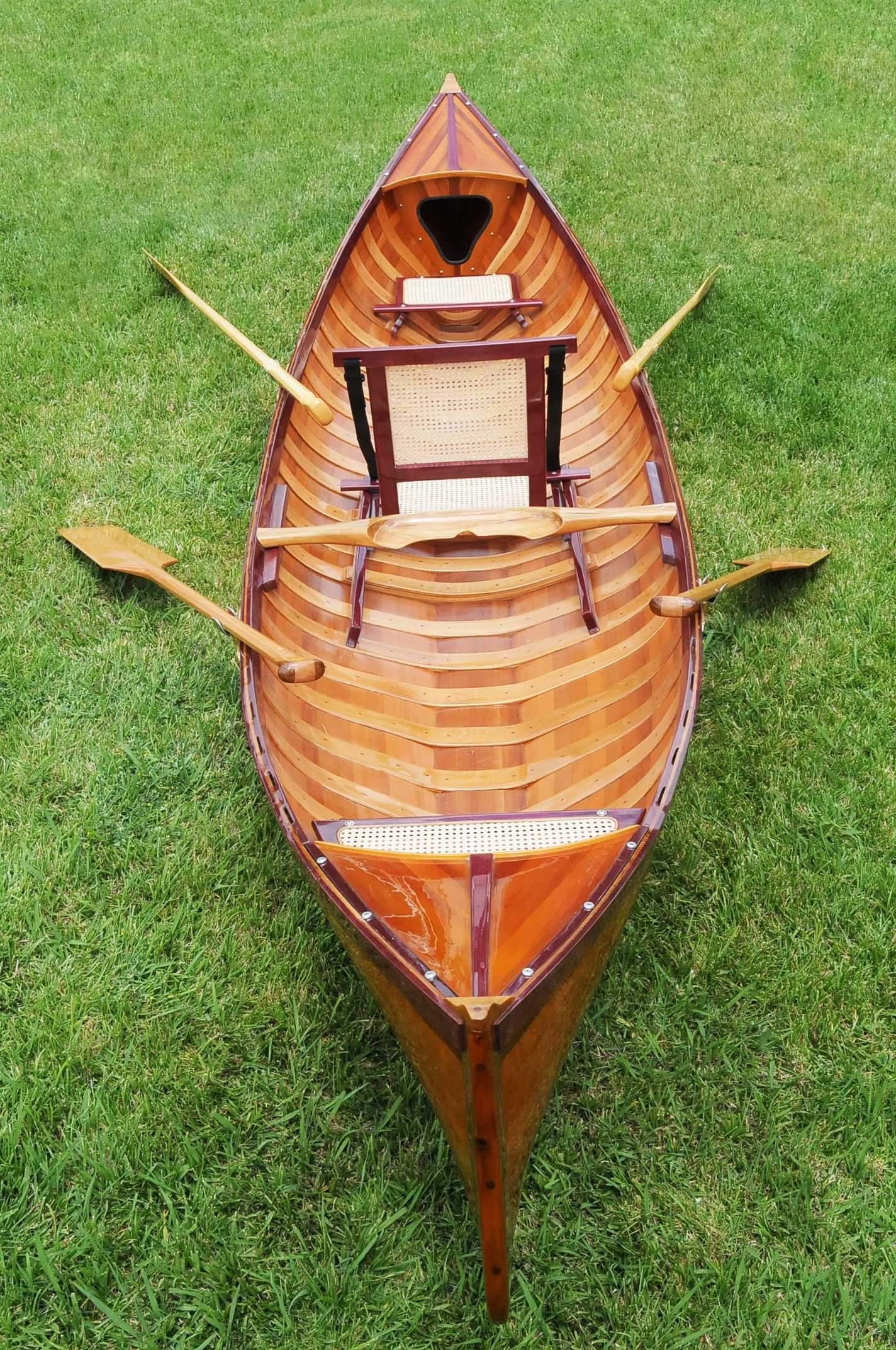 A handcrafted traditional wooden canoe made of red cedar, showcasing its clear graded hull and elegant design, perfect for serene water adventures.