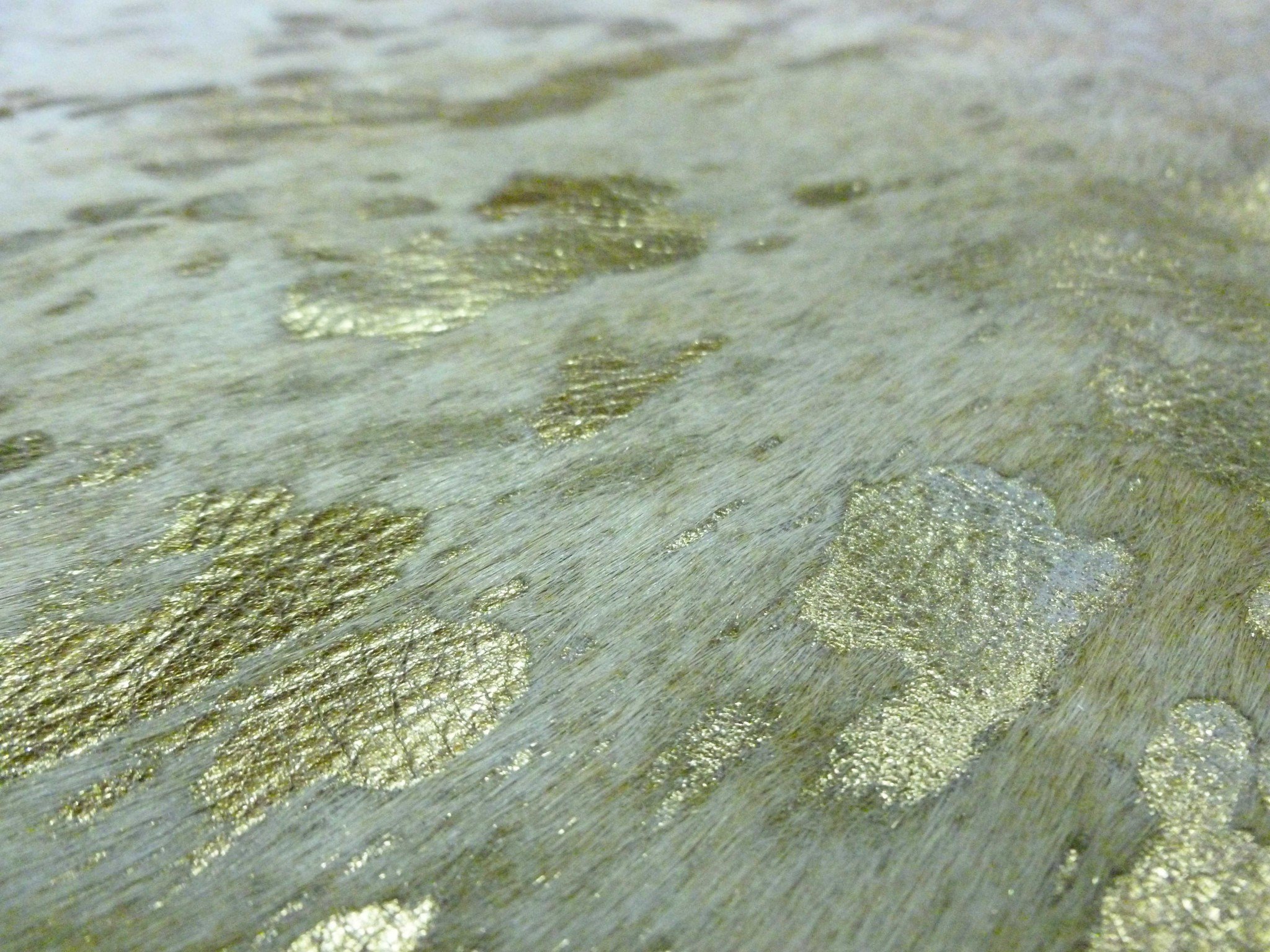 5.5 Ft Gold Devore on White Brindled Cowhide Rug showcasing unique patterns and textures, perfect for home decor.