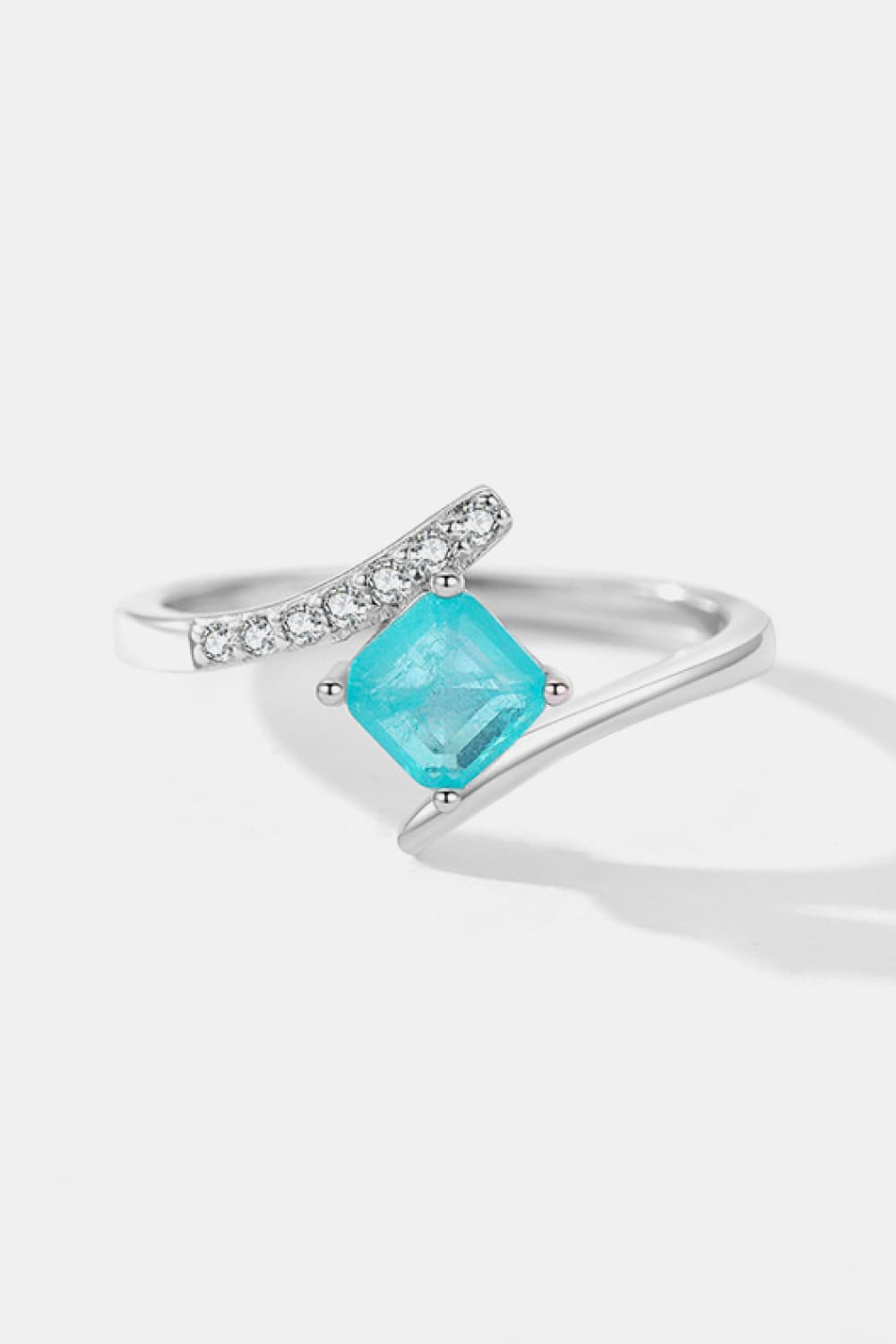 A minimalist 925 sterling silver square shape ring featuring a vibrant tourmaline stone, elegantly displayed on a soft background.