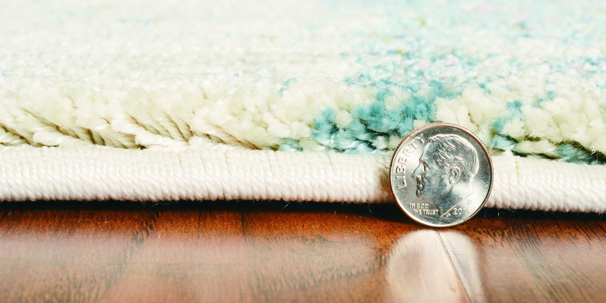 A large 94" x 134" seafoam polypropylene rug featuring a vintage traditional design with distressed touches, perfect for home decor.