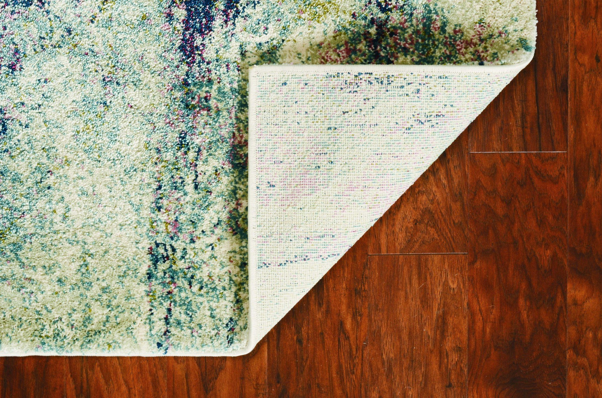 A large 94" x 134" seafoam polypropylene rug featuring a vintage traditional design with distressed touches, perfect for home decor.