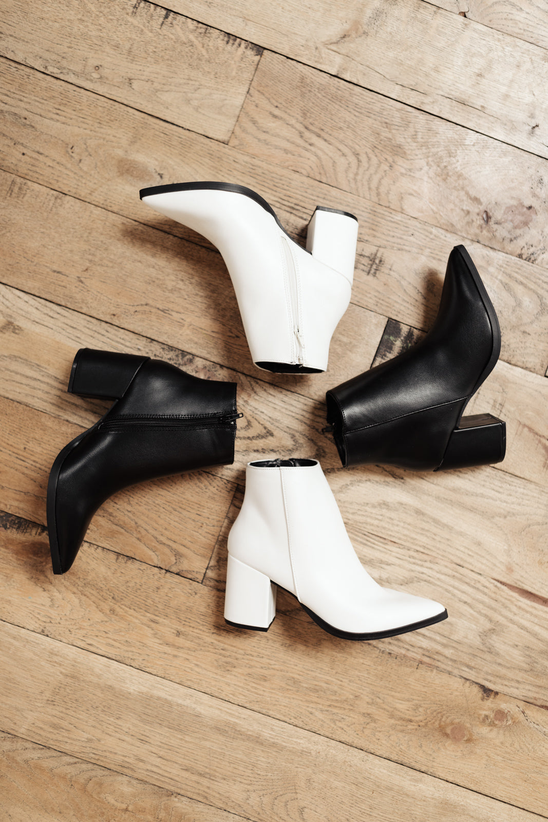 Chic white Amari ankle boots with pointed toe and zipper closure, perfect for stylish outfits.