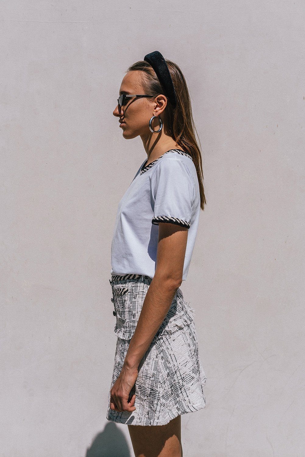 Ambre White T-shirt featuring trendy tweed detailing and a round neckline, styled with a mini-skirt.