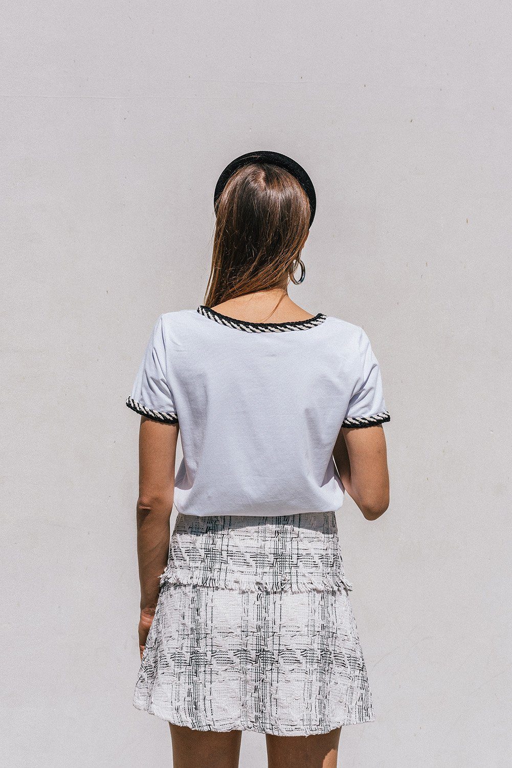 Ambre White T-shirt featuring trendy tweed detailing and a round neckline, styled with a mini-skirt.