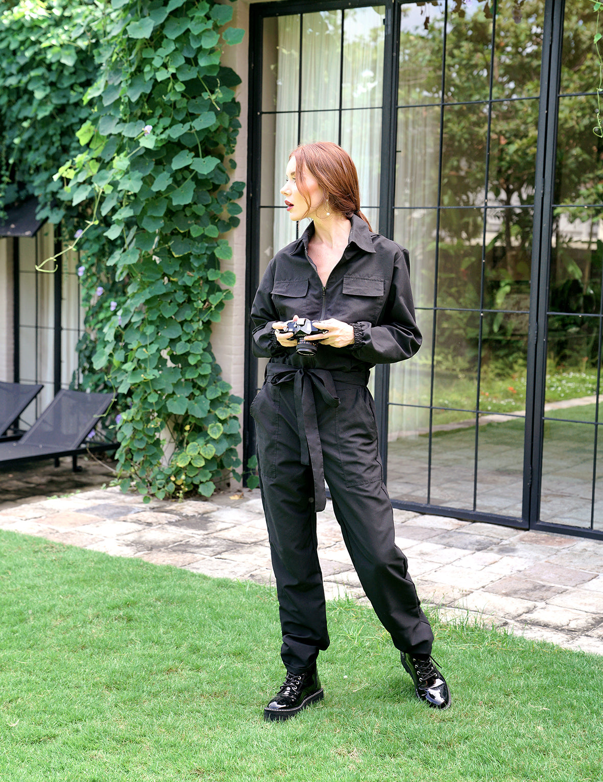 AMELIA Recycled Travel Jumpsuit in Black featuring a relaxed fit, spread collar, tie waist, and utility pockets, made from recycled fabric.