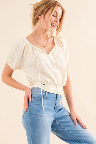 And The Why Cotton Gauze Back Waist Tie Cropped Blouse in a stylish design, showcasing the unique back waist tie and lightweight fabric.