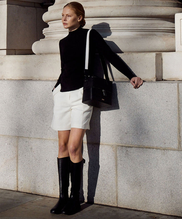Anell Golf Classic Slim Knit Top in Black featuring a turtleneck and diagonal design details.