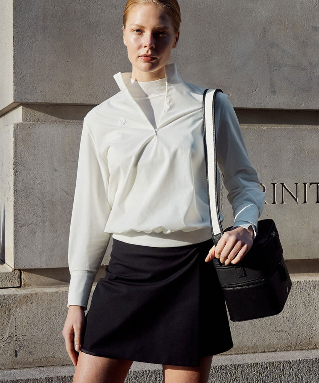 Anell Golf Cotton Wrap Skirt Pants in Black, showcasing a stylish semi-A-line design with a diagonal slit for a flattering fit.