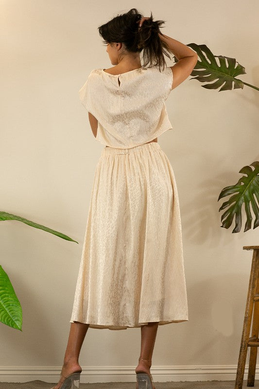 A stylish animal print cropped skirt set featuring a trendy top and flowing skirt, perfect for parties and casual outings.