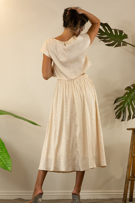 A stylish animal print cropped skirt set featuring a trendy top and flowing skirt, perfect for parties and casual outings.