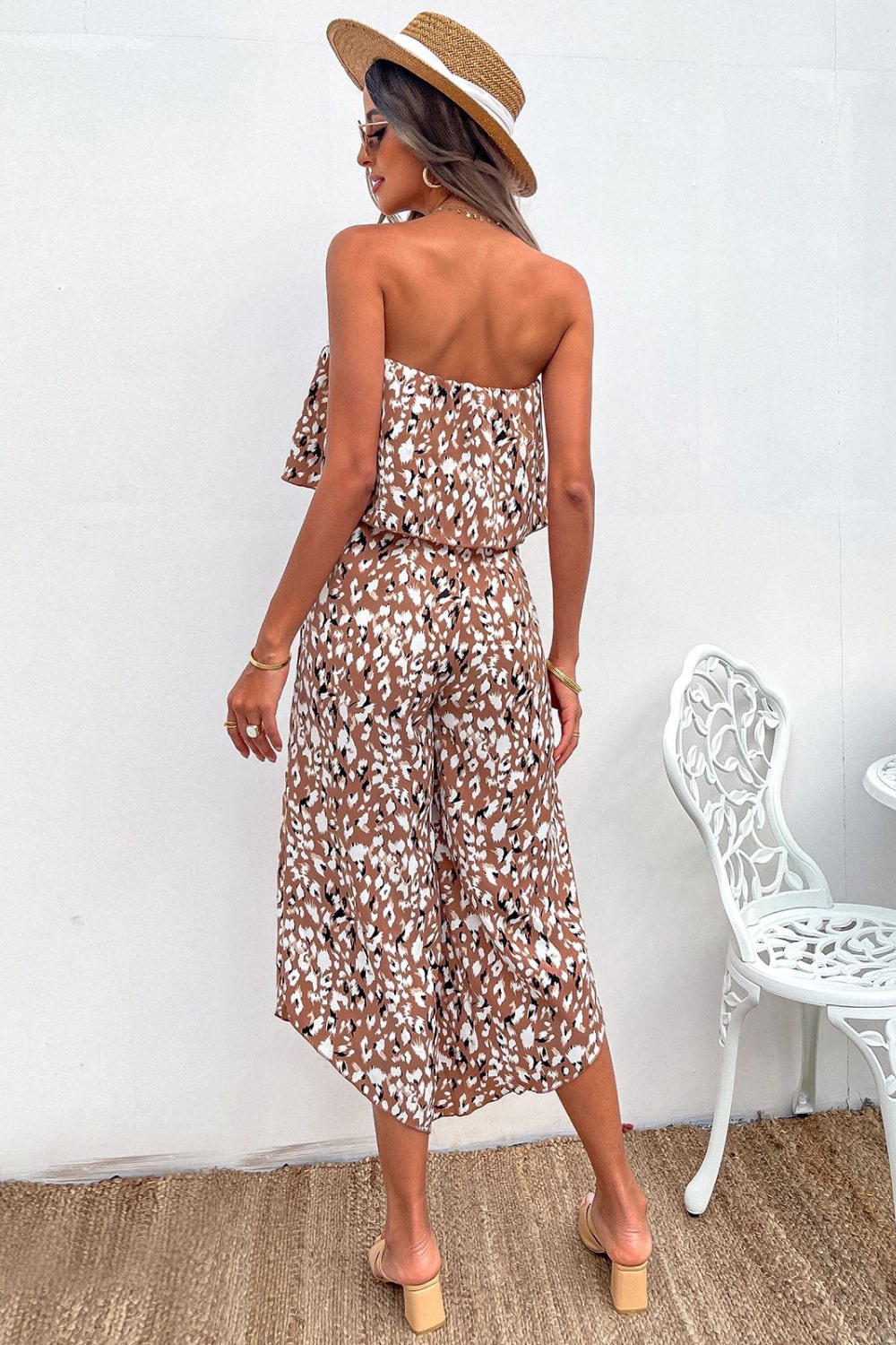 A stylish animal print strapless layered jumpsuit displayed on a mannequin, showcasing its elegant design and vibrant colors.