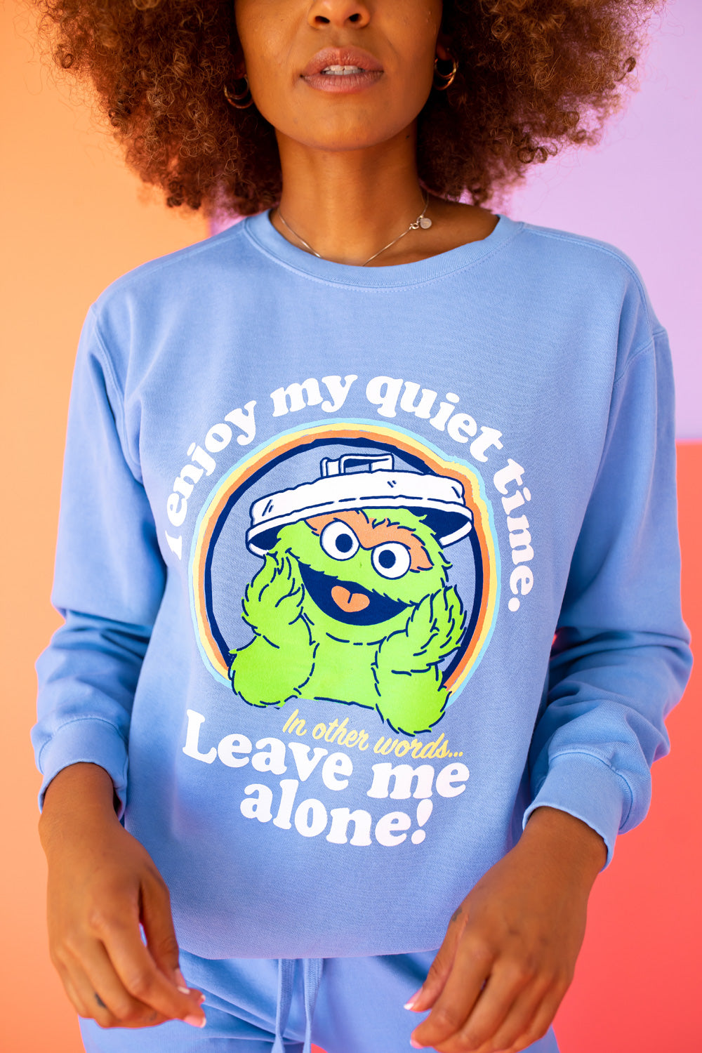 A vibrant blue sweatshirt featuring Oscar The Grouch, showcasing a playful design perfect for casual wear.