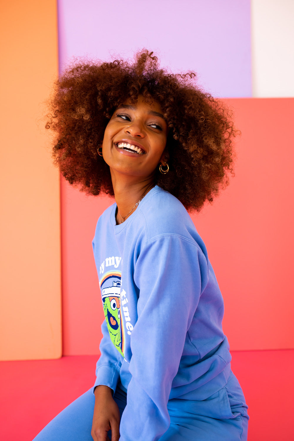 A vibrant blue sweatshirt featuring Oscar The Grouch, showcasing a playful design perfect for casual wear.