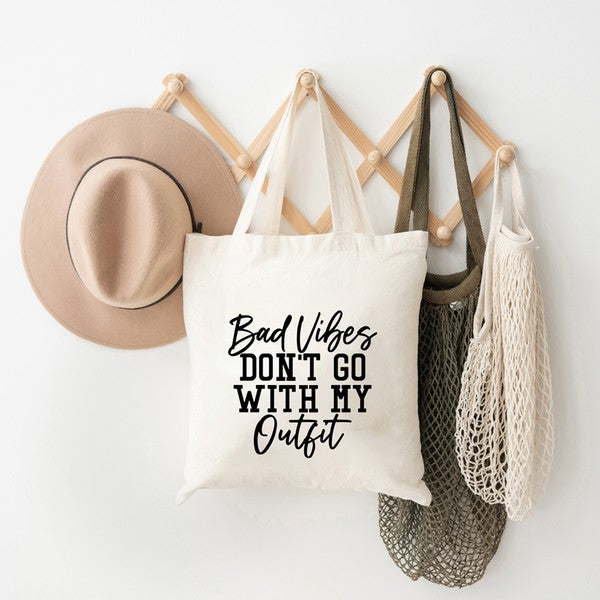 A stylish canvas tote bag with the phrase 'Bad Vibes Don't Go' printed on it, perfect for everyday use.