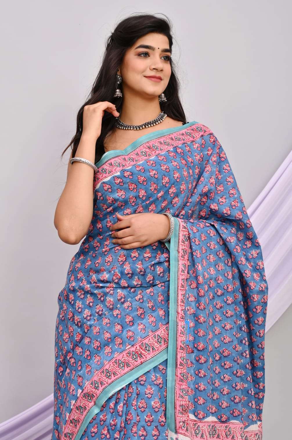 A beautiful Bagru hand block printed Kota Doria saree showcasing intricate patterns and vibrant colors, draped elegantly.