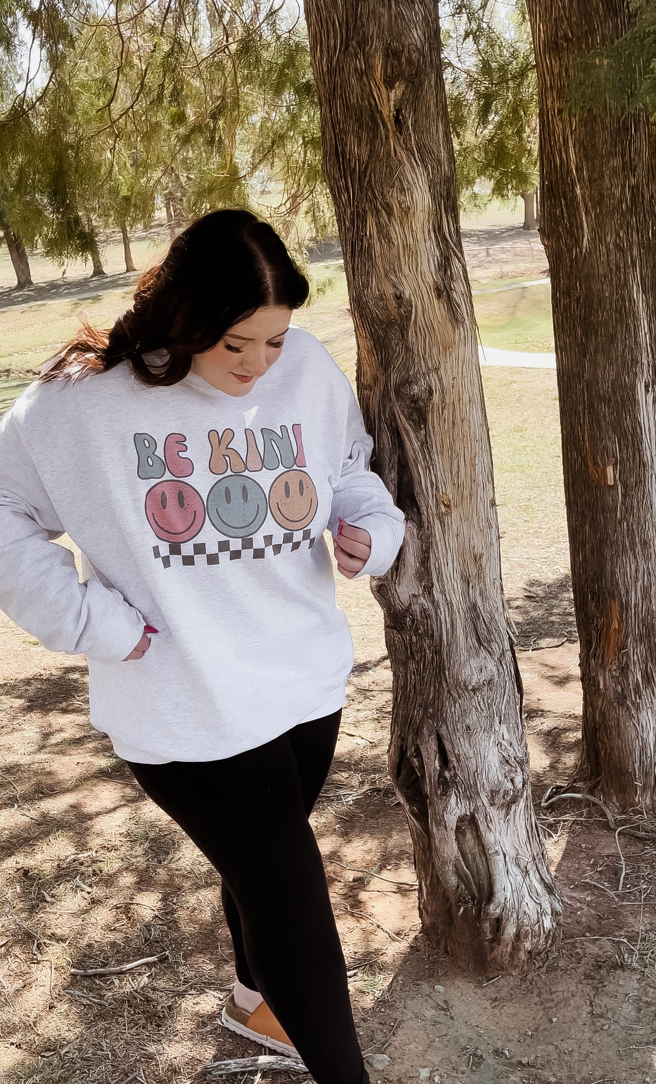 Be Kind Smiley Sweatshirt featuring a cheerful smiley face graphic on a cozy fabric, perfect for spreading positivity.