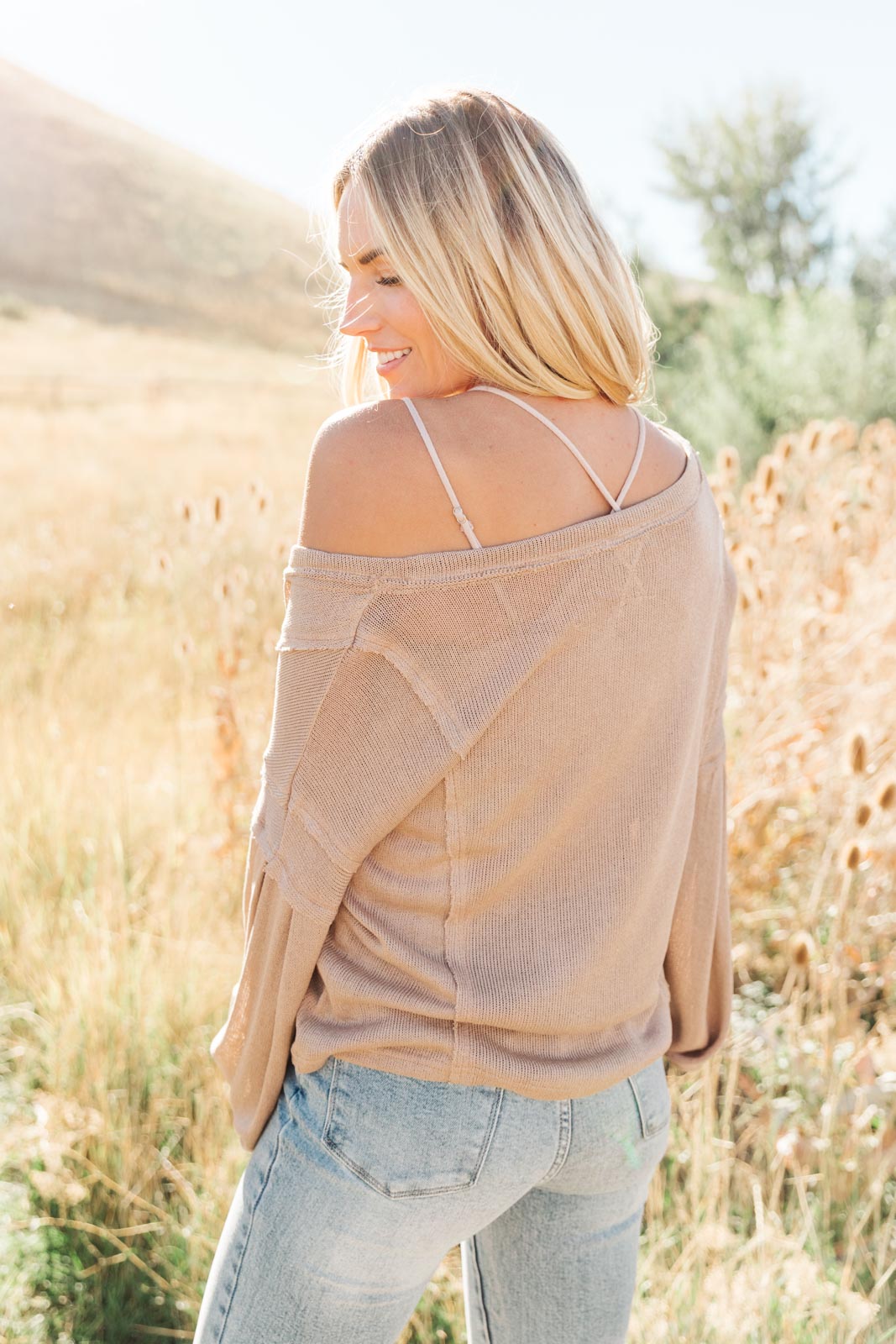 Bellissimo Draped V-Neck Sweater in Mocha, showcasing its deep V-neckline and raw stitching details.