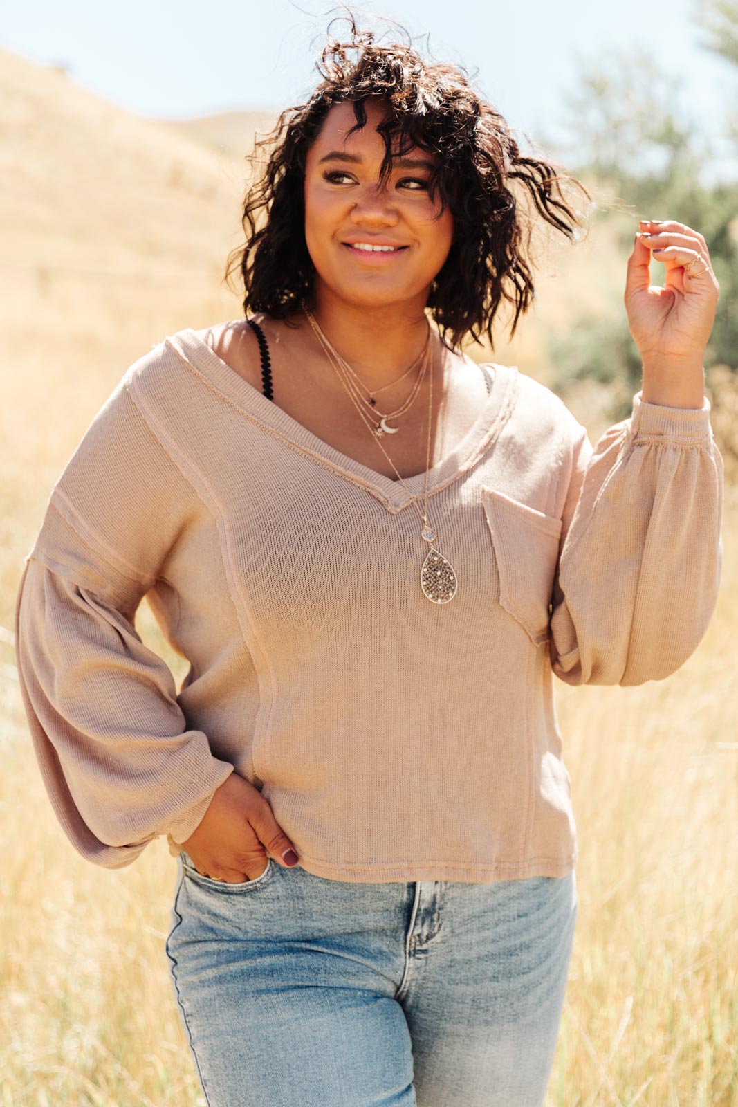 Bellissimo Draped V-Neck Sweater in Mocha, showcasing its deep V-neckline and raw stitching details.