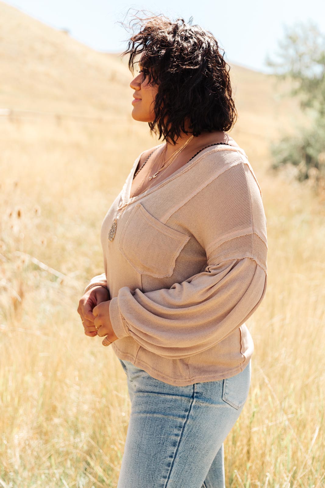 Bellissimo Draped V-Neck Sweater in Mocha, showcasing its deep V-neckline and raw stitching details.