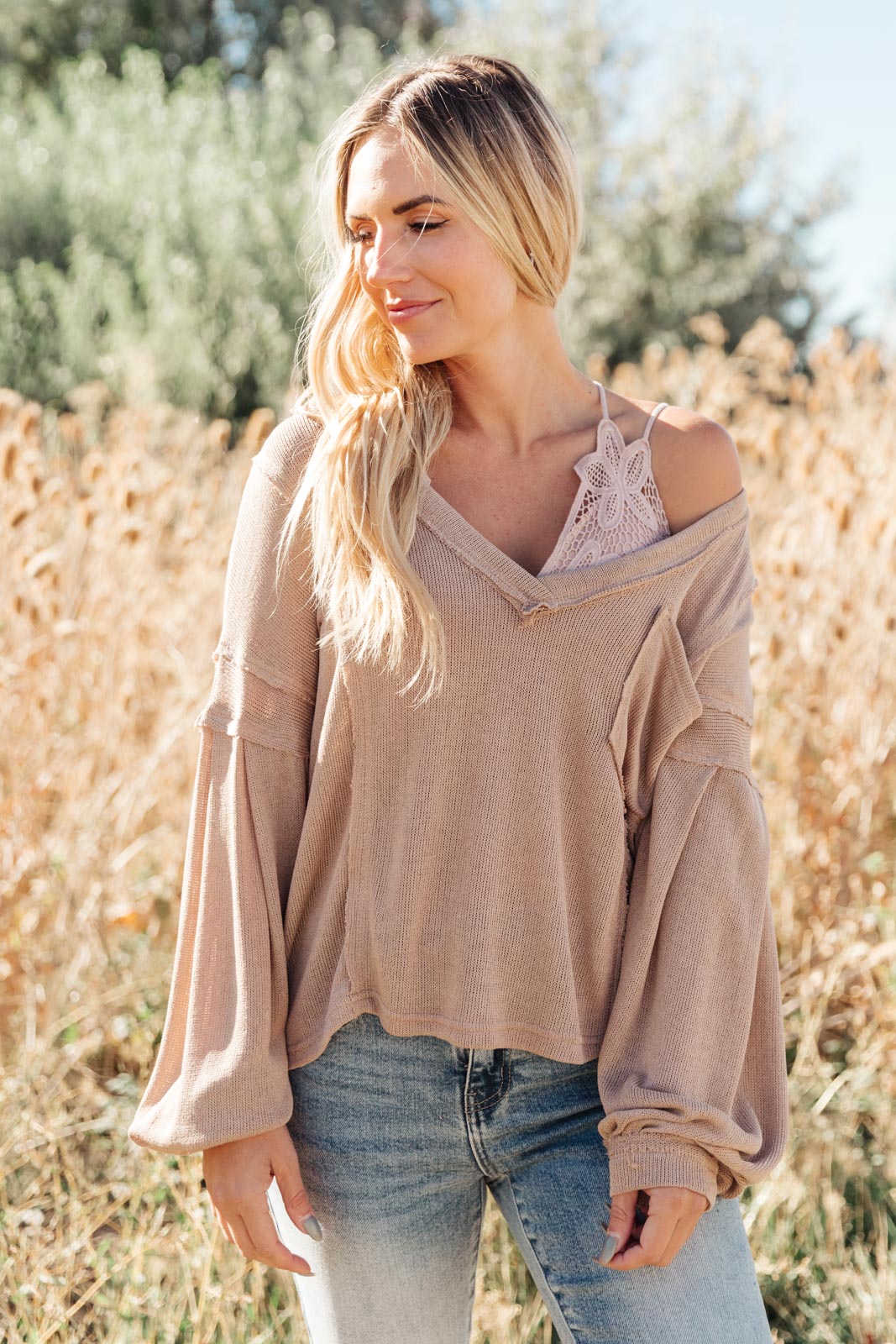 Bellissimo Draped V-Neck Sweater in Mocha, showcasing its deep V-neckline and raw stitching details.