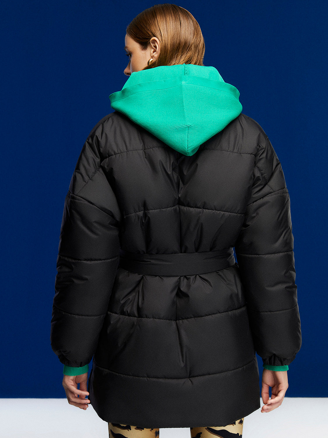 A stylish belted puffer jacket featuring a double-breasted design, wide neck, and side zipper pockets, perfect for winter fashion.