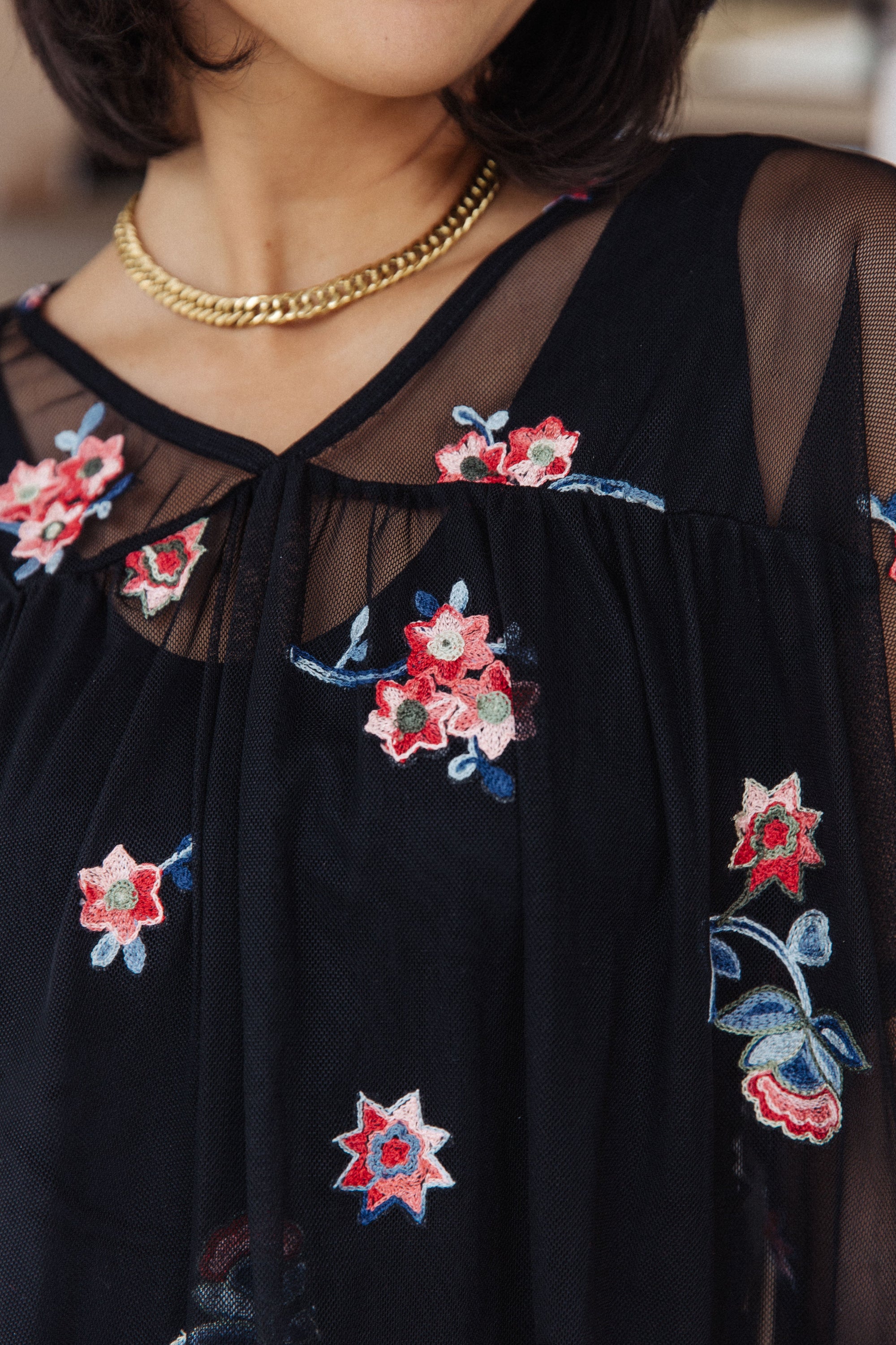 A stylish Best We've Got Embroidered Blouse featuring delicate floral embroidery on soft mesh, with dolman sleeves and a v-neckline.