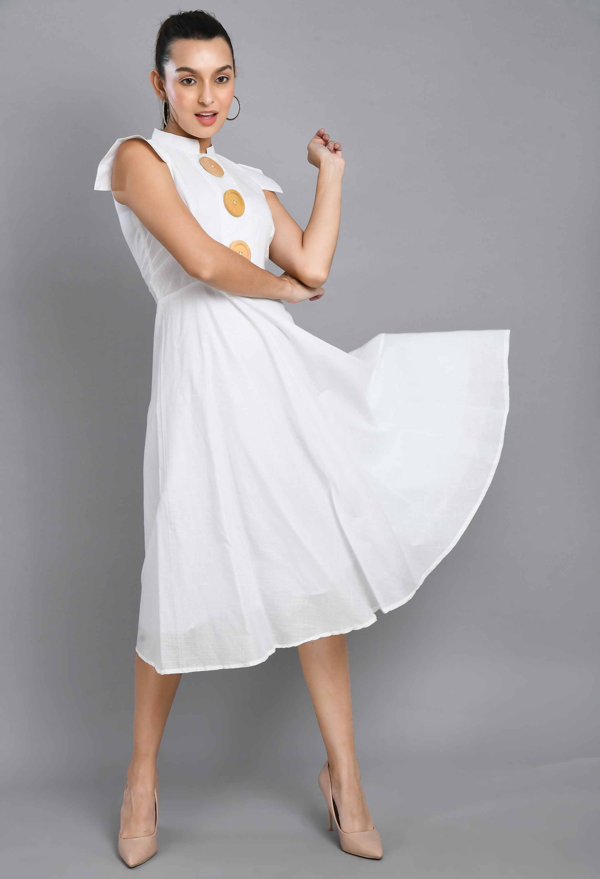 A stylish white dress featuring large wooden buttons, designed with a flare fit and asymmetrical hem, perfect for casual and semi-festive occasions.