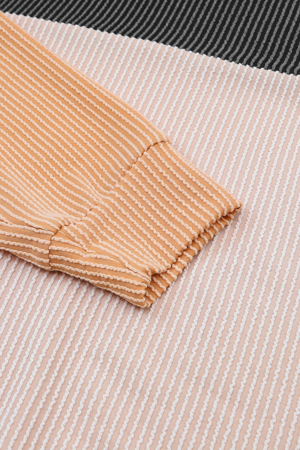 A stylish black color block long sleeve ribbed loose top displayed on a mannequin, showcasing its chic design and comfortable fit.