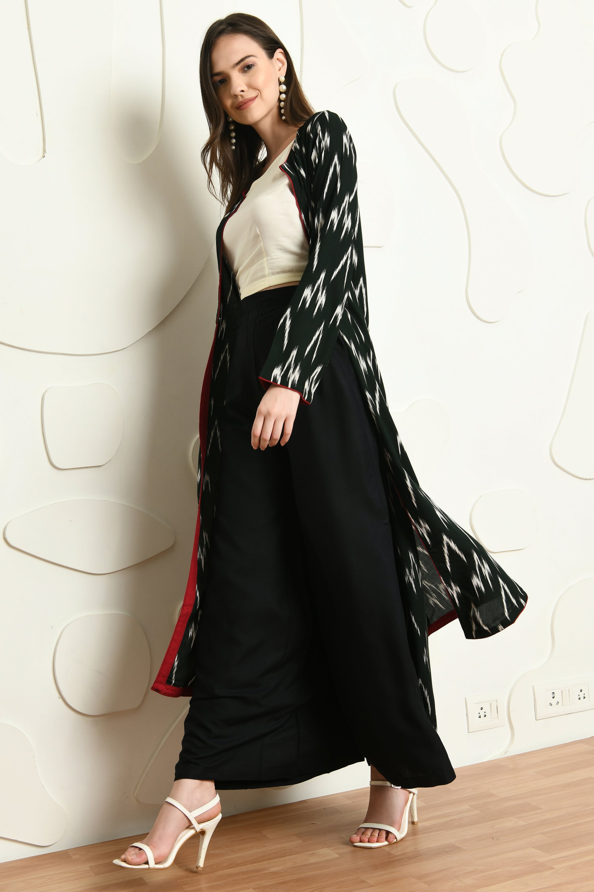 A stylish three-piece outfit featuring a black jacket, sleeveless crop top, and palazzo pants, perfect for semi-formal occasions.