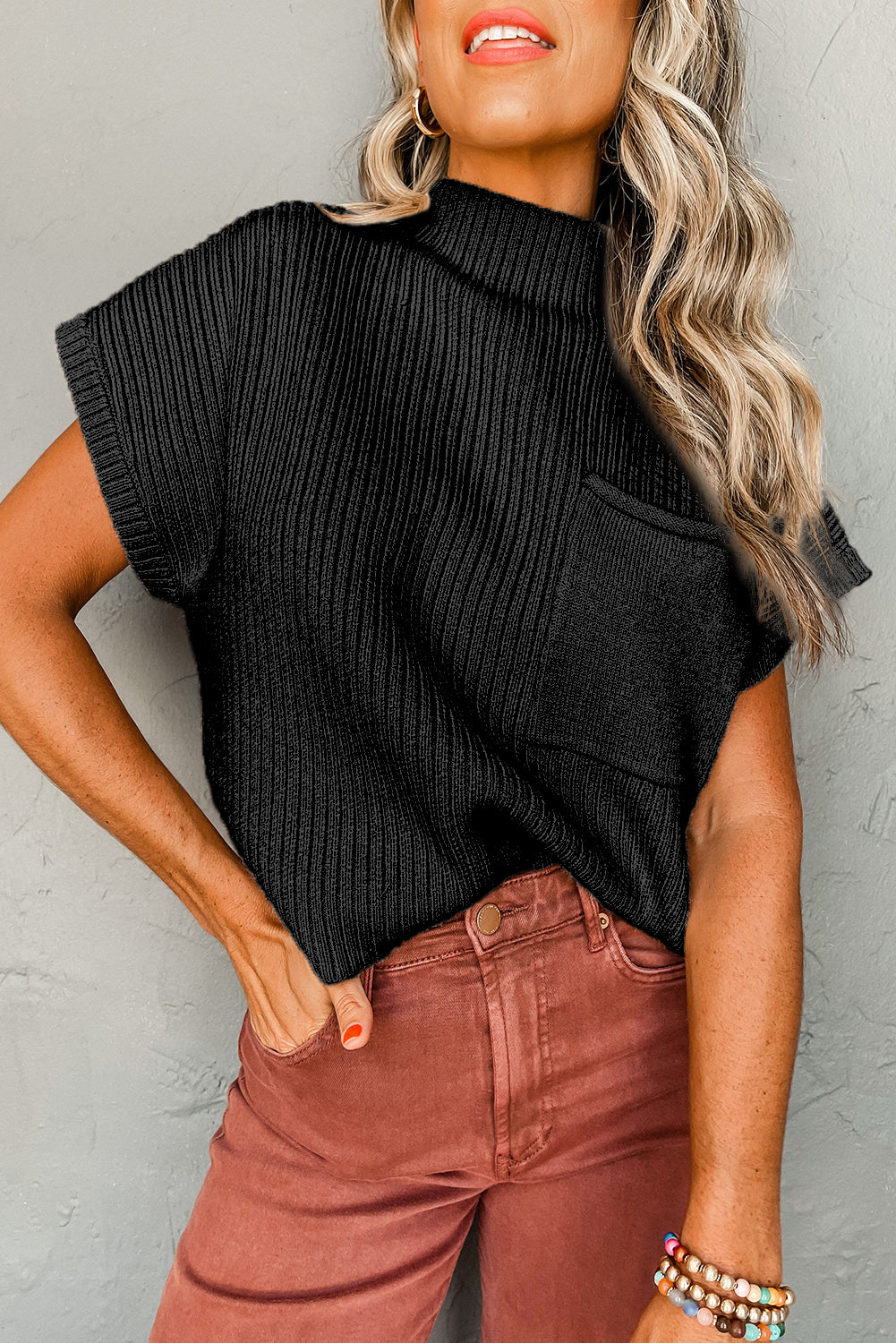 Black ribbed knit short sleeve sweater with a patch pocket, showcasing a stylish and cozy design.