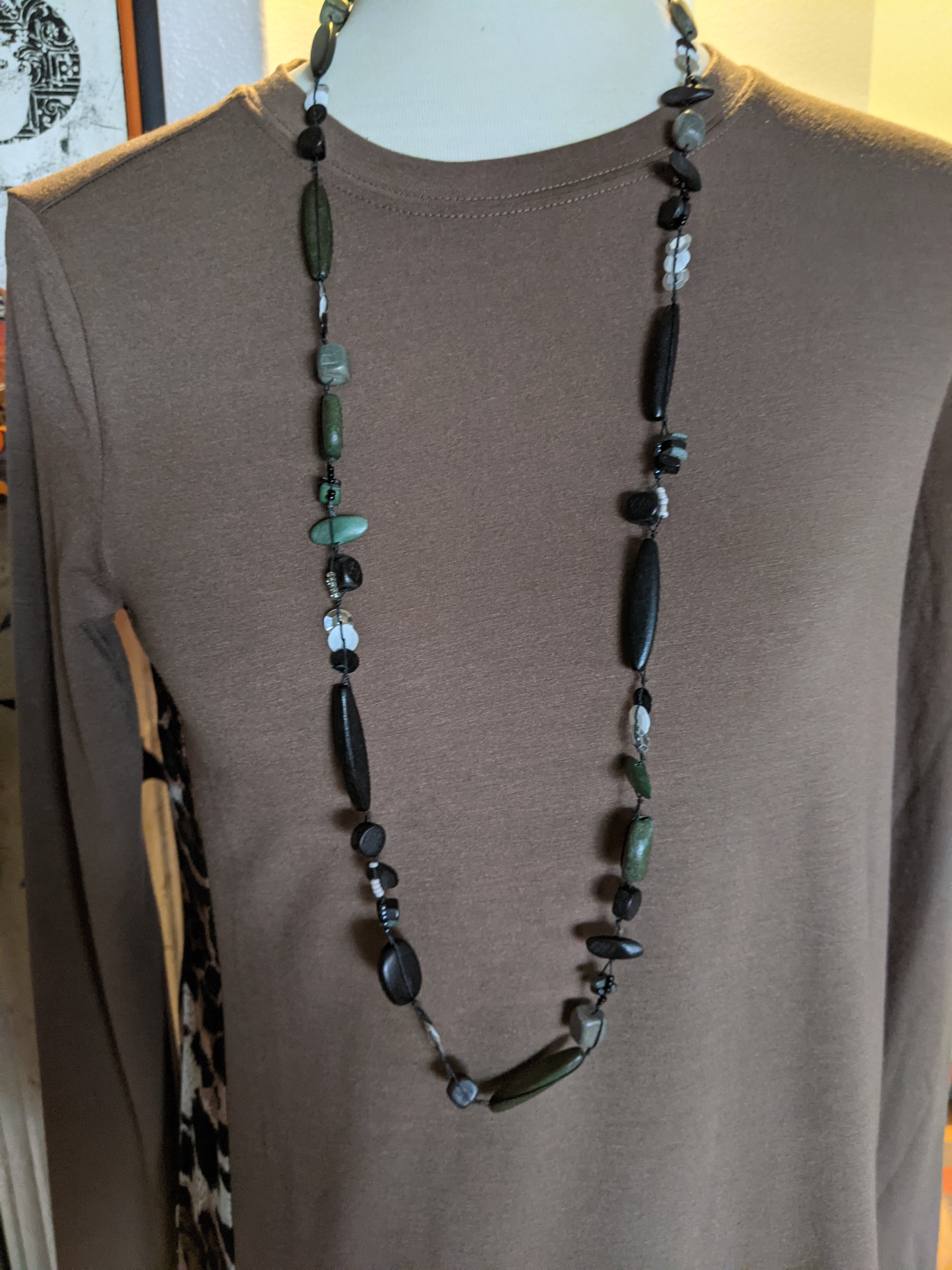 A stylish long necklace featuring black wooden beads and sparkling sequins, perfect for enhancing any outfit.