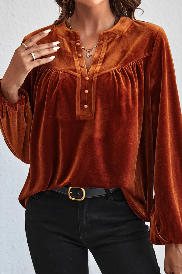 Elegant red blouse made of imitation velvet with V-neck and long sleeves, featuring decorative buttons and a loose fit.
