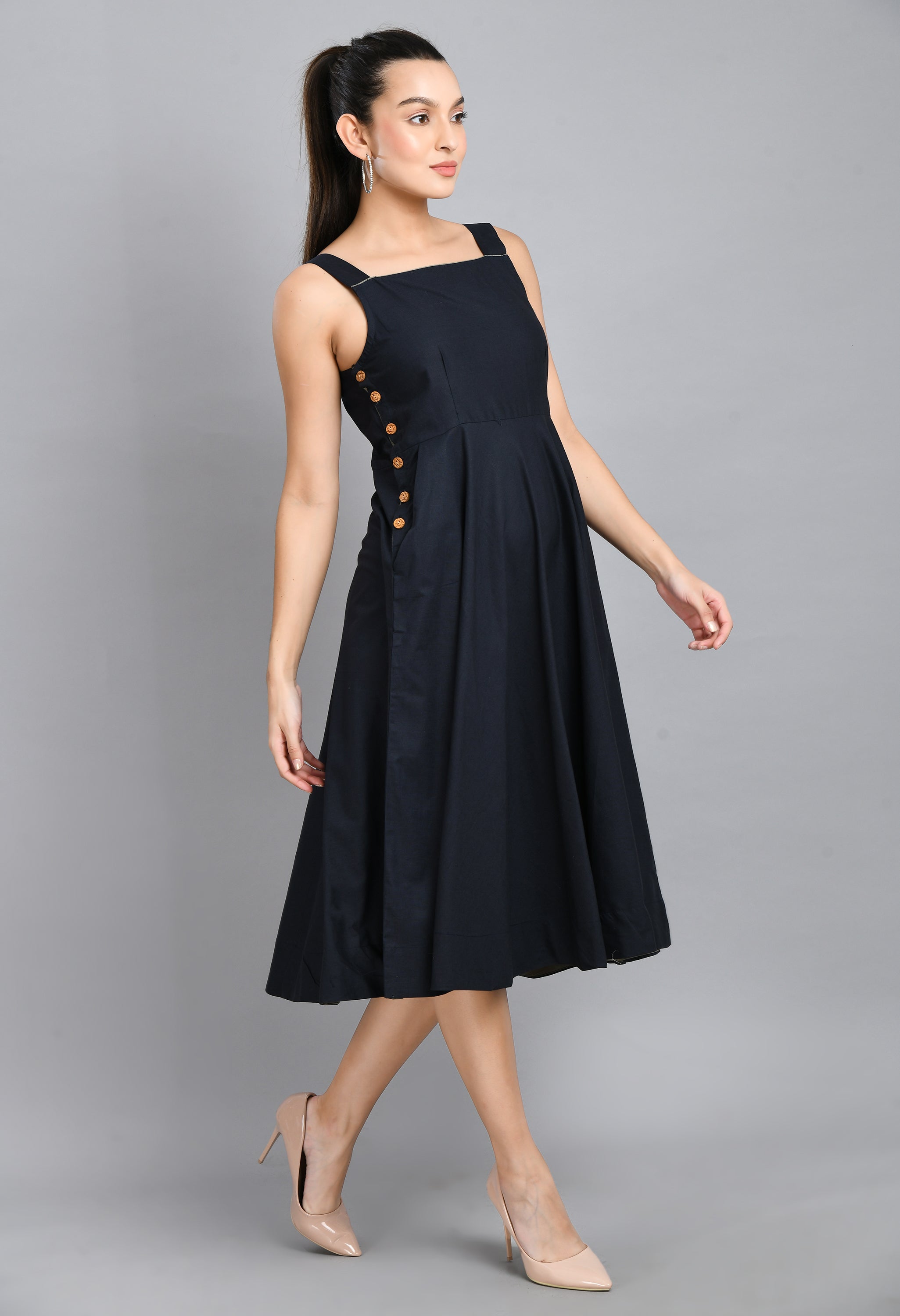 A stylish blue linen sleeveless dress with wood buttons and an asymmetrical hem, perfect for casual wear.