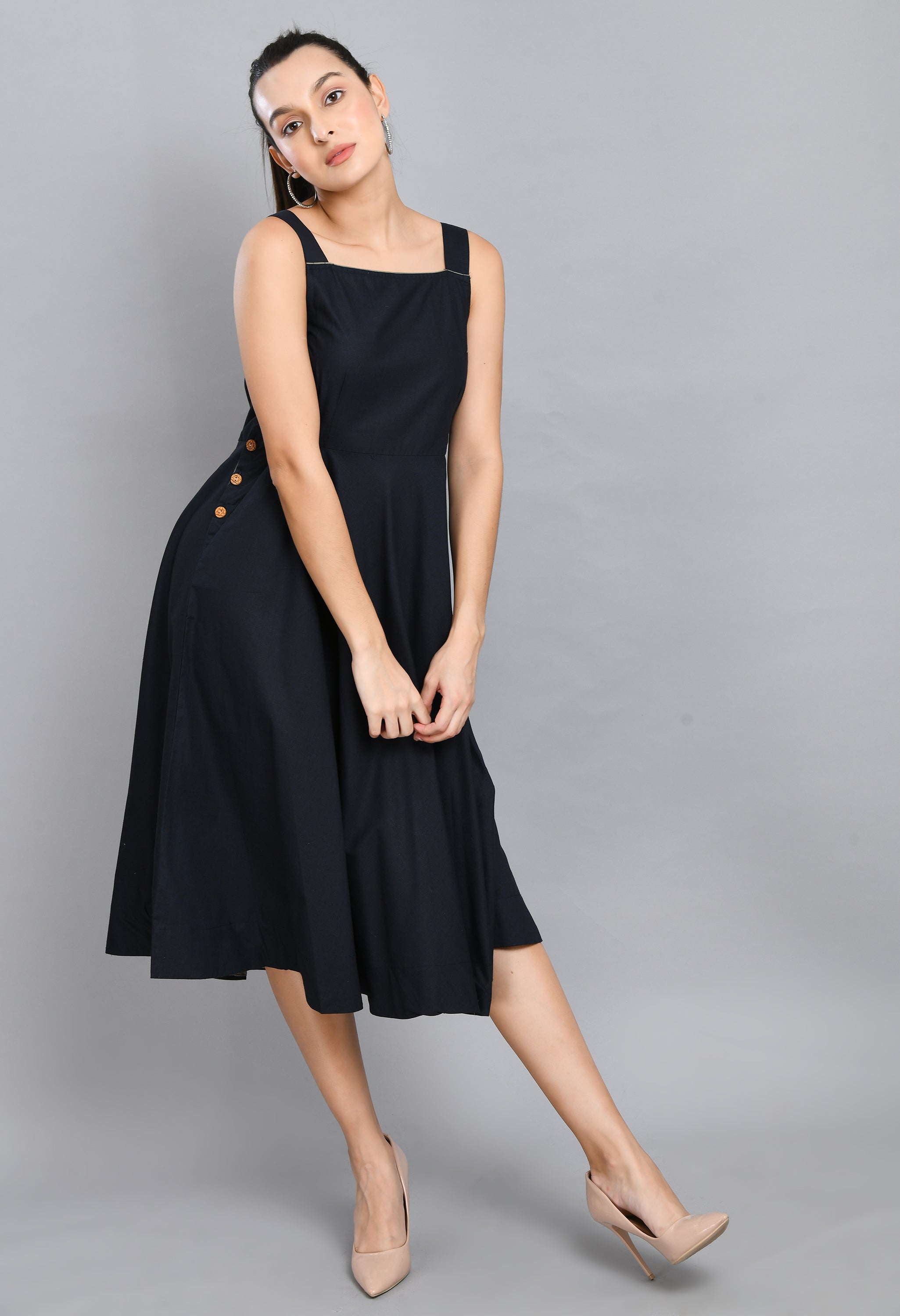 A stylish blue linen sleeveless dress with wood buttons and an asymmetrical hem, perfect for casual wear.