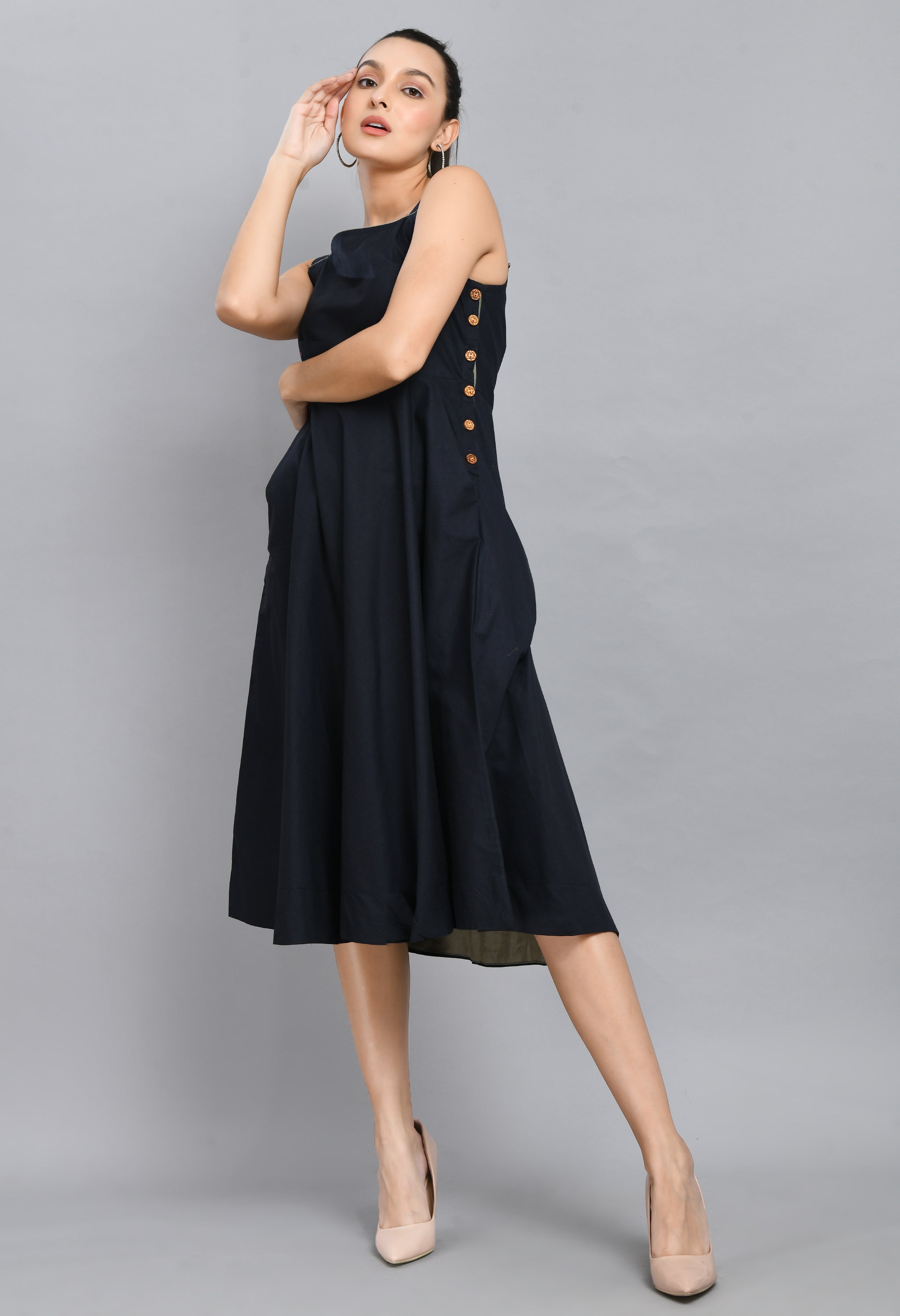 A stylish blue linen sleeveless dress with wood buttons and an asymmetrical hem, perfect for casual wear.