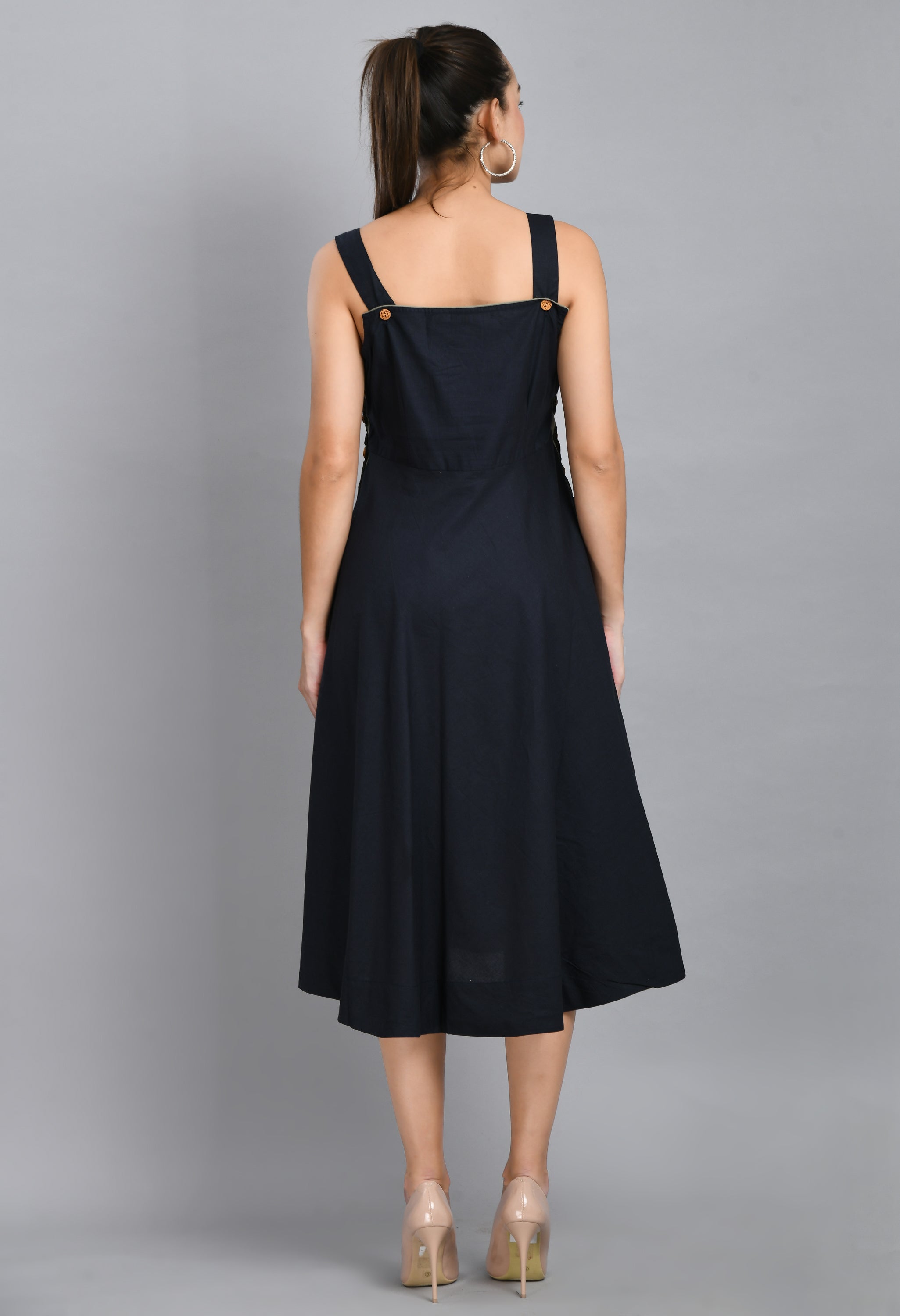 A stylish blue linen sleeveless dress with wood buttons and an asymmetrical hem, perfect for casual wear.