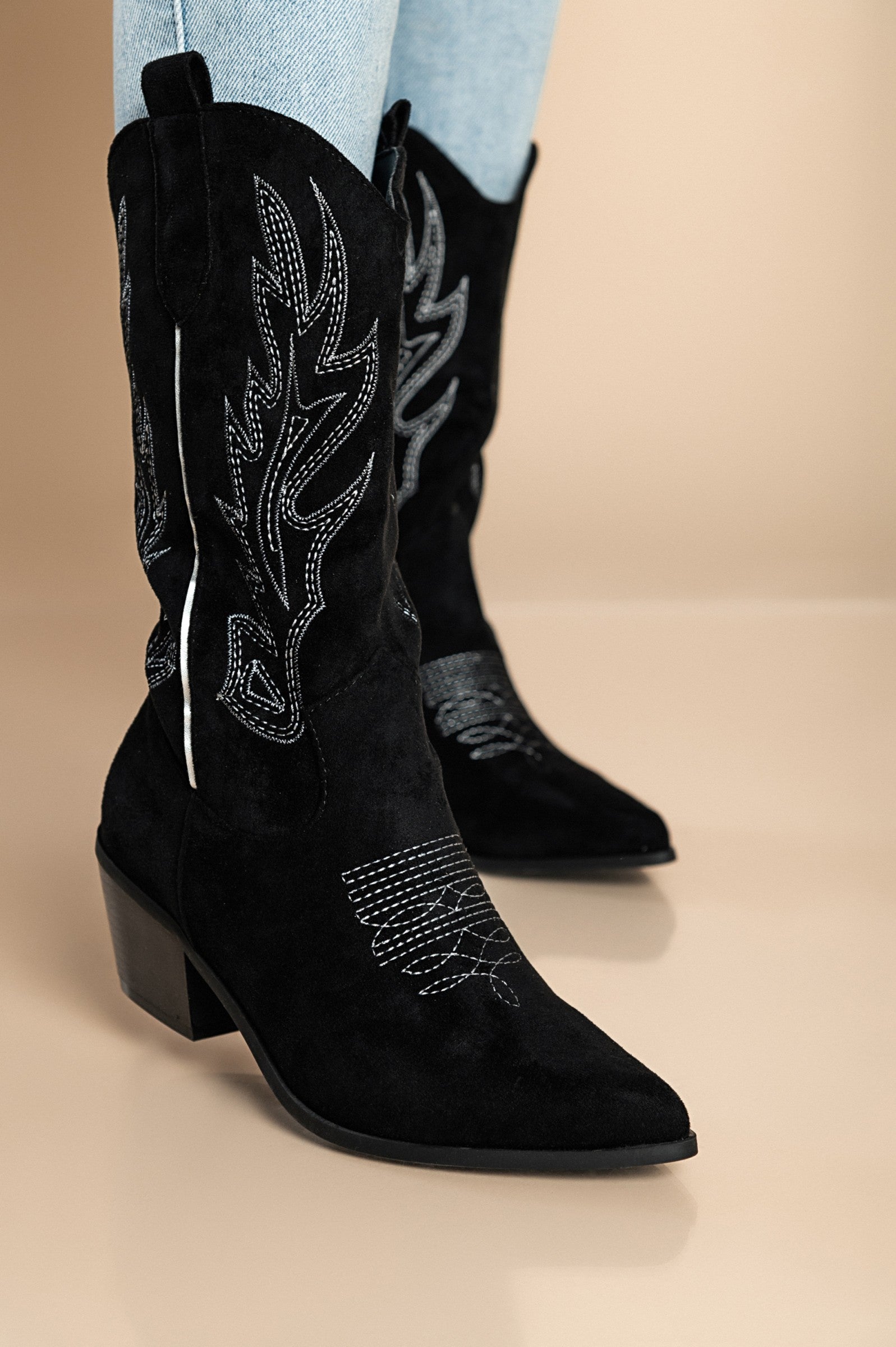 Stylish black boots with decorative details, featuring a thick heel and pointed toe design, perfect for any occasion.