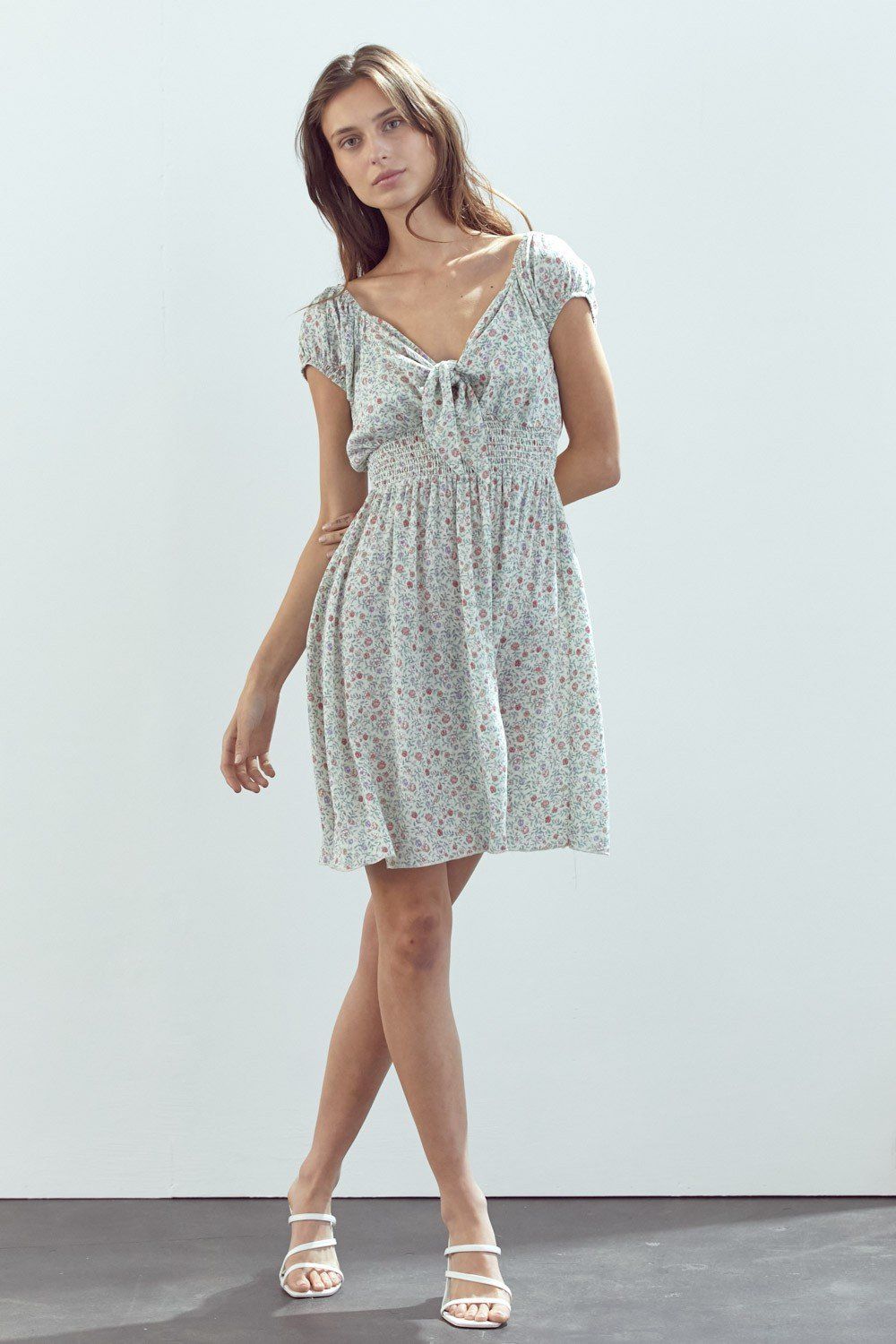Emma dress featuring a bow tie front and cap sleeves in a daisy floral print, made from lightweight rayon gauze.