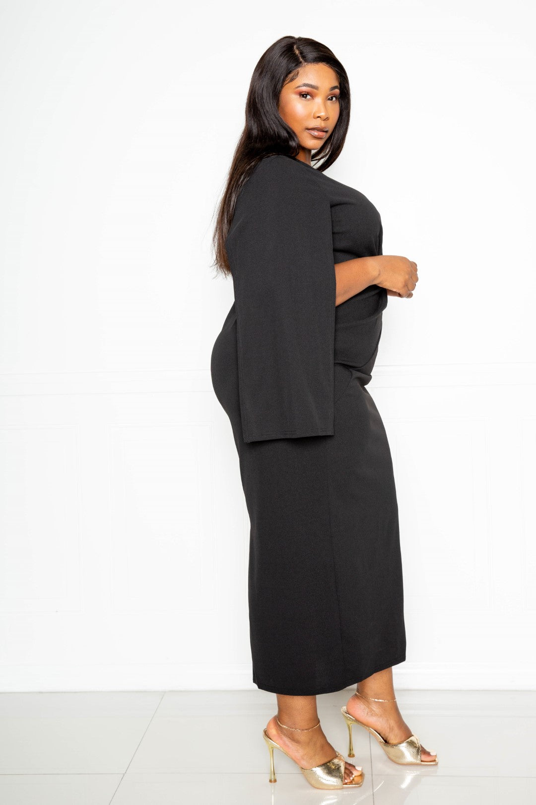 A stylish black cape sleeve dress featuring a knot detail at the waist, designed for plus sizes.
