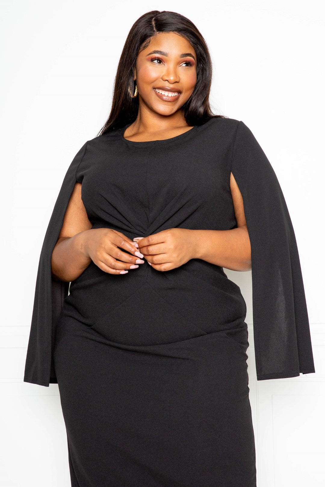 A stylish black cape sleeve dress featuring a knot detail at the waist, designed for plus sizes.