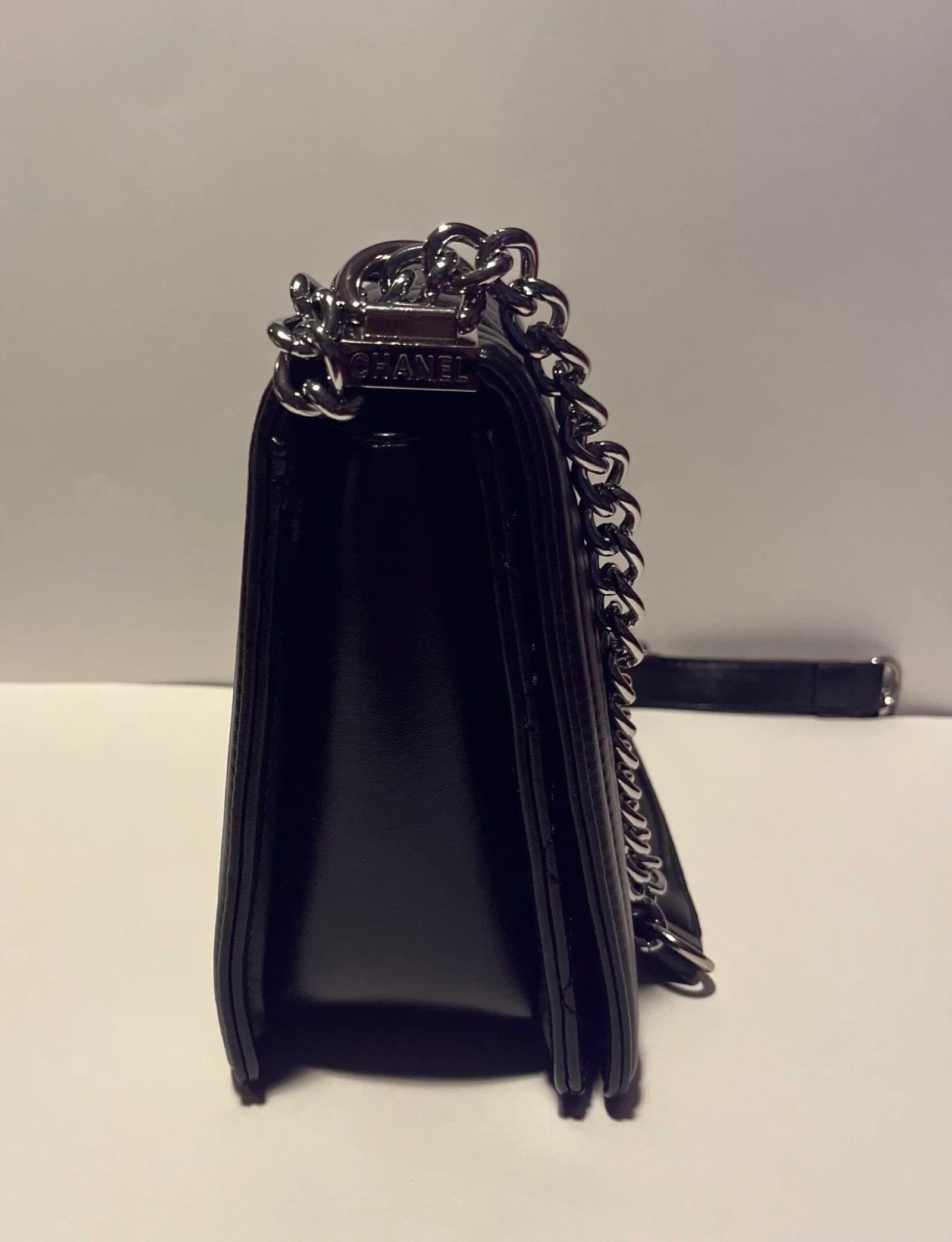 Charming shoulder bag with gold handle chain, featuring quilted design and silver-tone hardware.