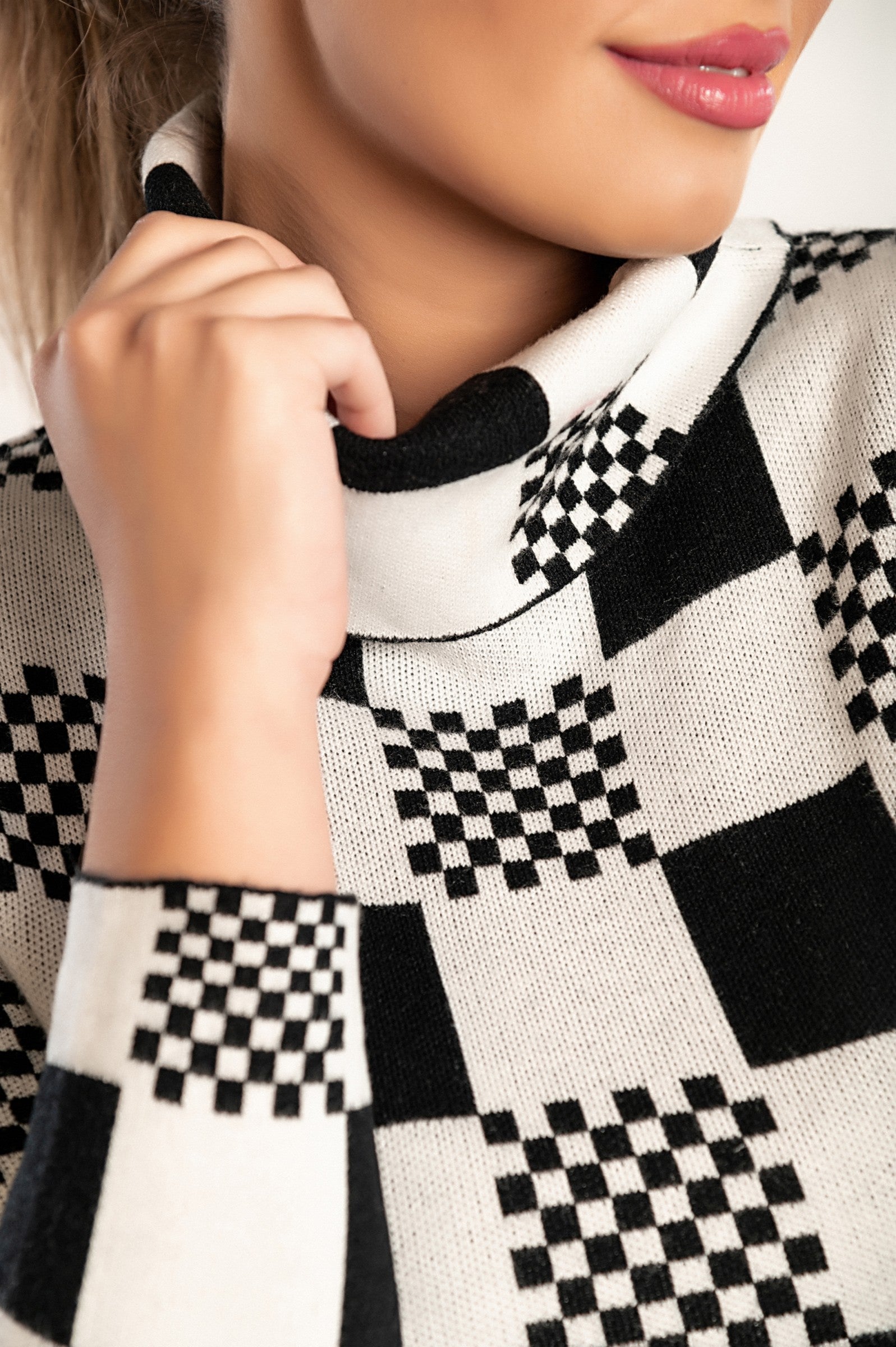 White check print sweater Roldana with long sleeves and folded neck, showcasing a stylish checkerboard pattern.