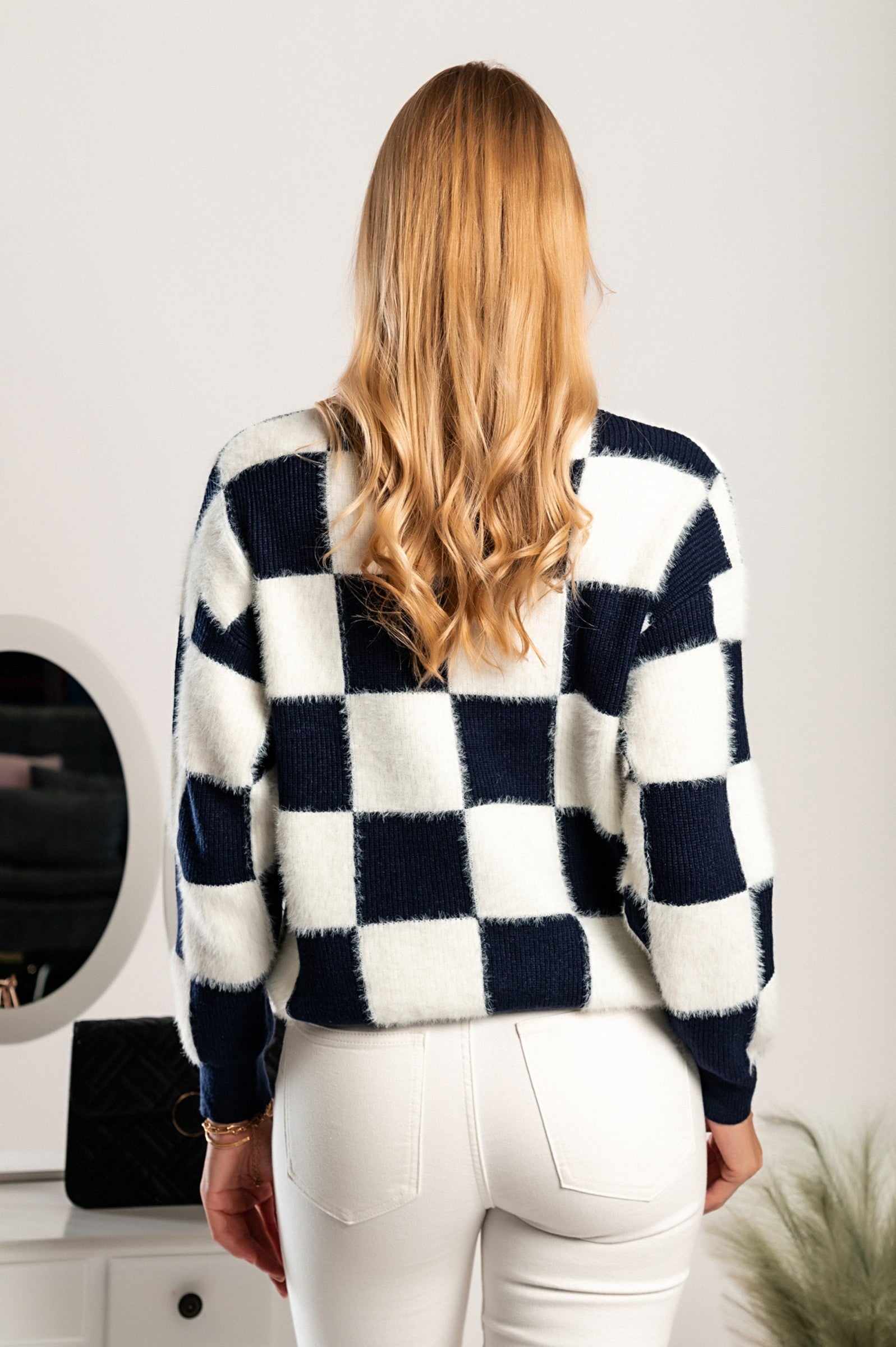 Checkerboard print sweater in blue and white, featuring long sleeves and a round neckline, made from soft fabric.