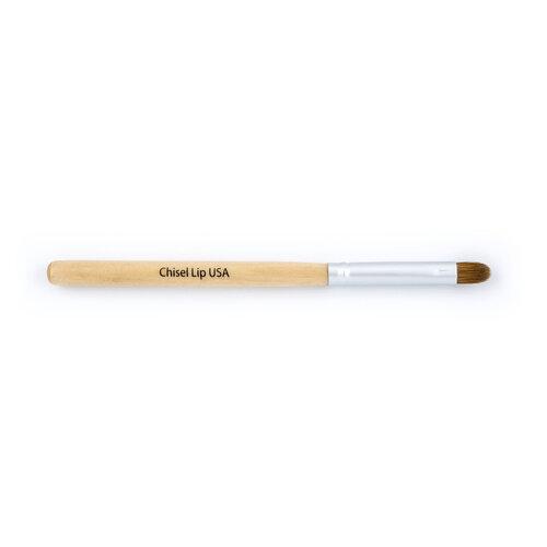 A close-up of a 100% natural chisel lip brush with angled bristles, perfect for precise lip application.