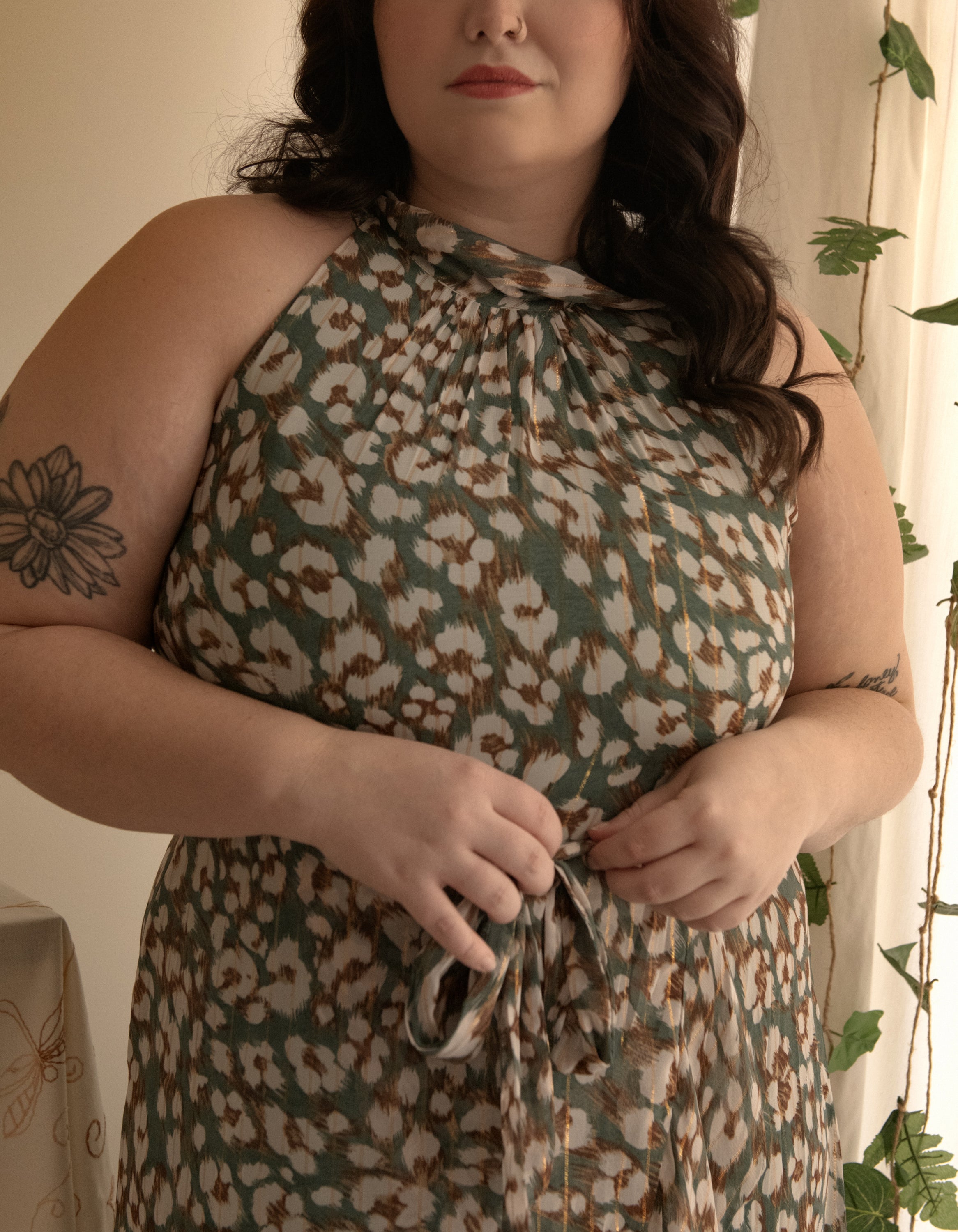 Clemence Midi Dress featuring an asymmetrical faux wrap design, high halter neckline, and wildflower print in sage green.