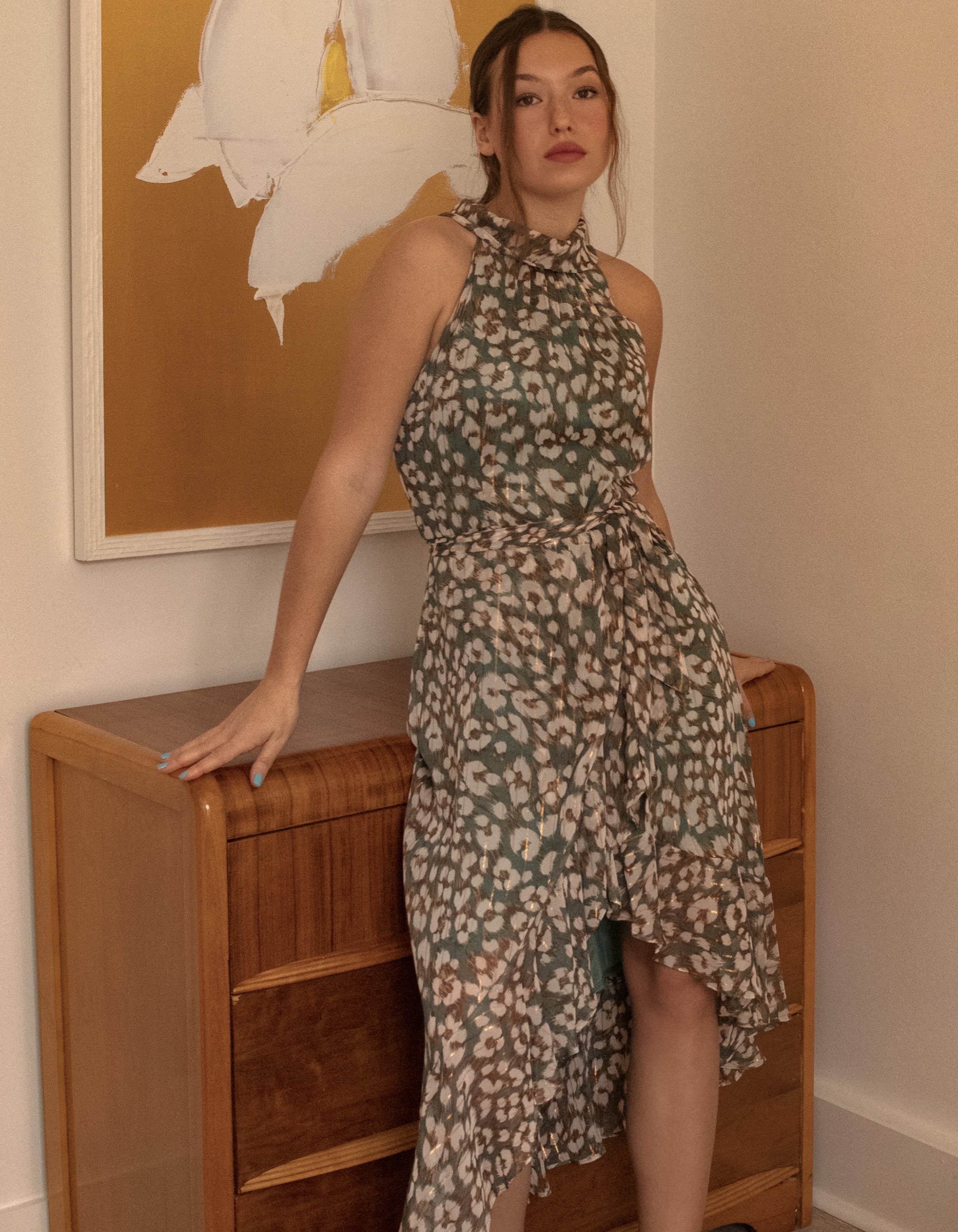 Clemence Midi Dress featuring an asymmetrical faux wrap design, high halter neckline, and wildflower print in sage green.