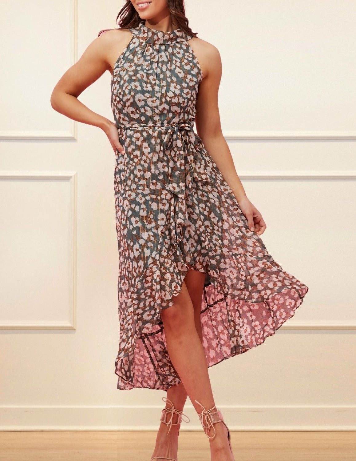 Clemence Midi Dress featuring an asymmetrical faux wrap design, high halter neckline, and wildflower print in sage green.