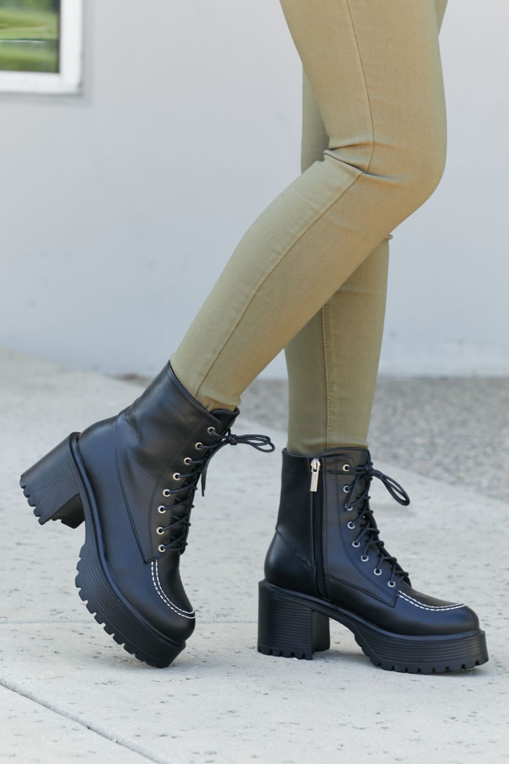 Climbing the Ranks Platform Combat Boots in Black featuring contrast stitching and chunky sole, showcasing stylish design and quality craftsmanship.