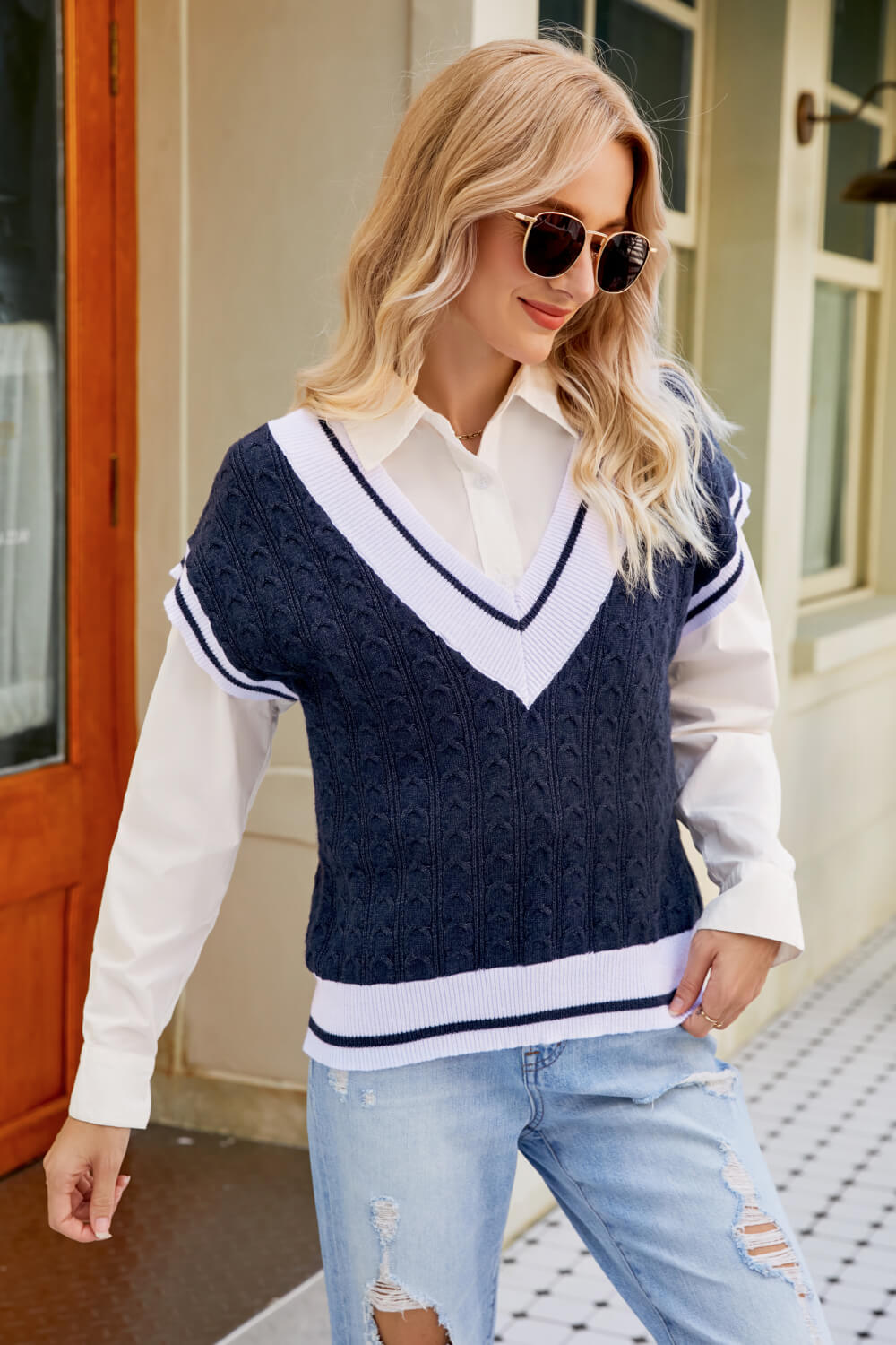 A stylish Contrast V-Neck Cap Sleeve Sweater Vest displayed outdoors, featuring a chic design with a contrast pattern and cap sleeves.