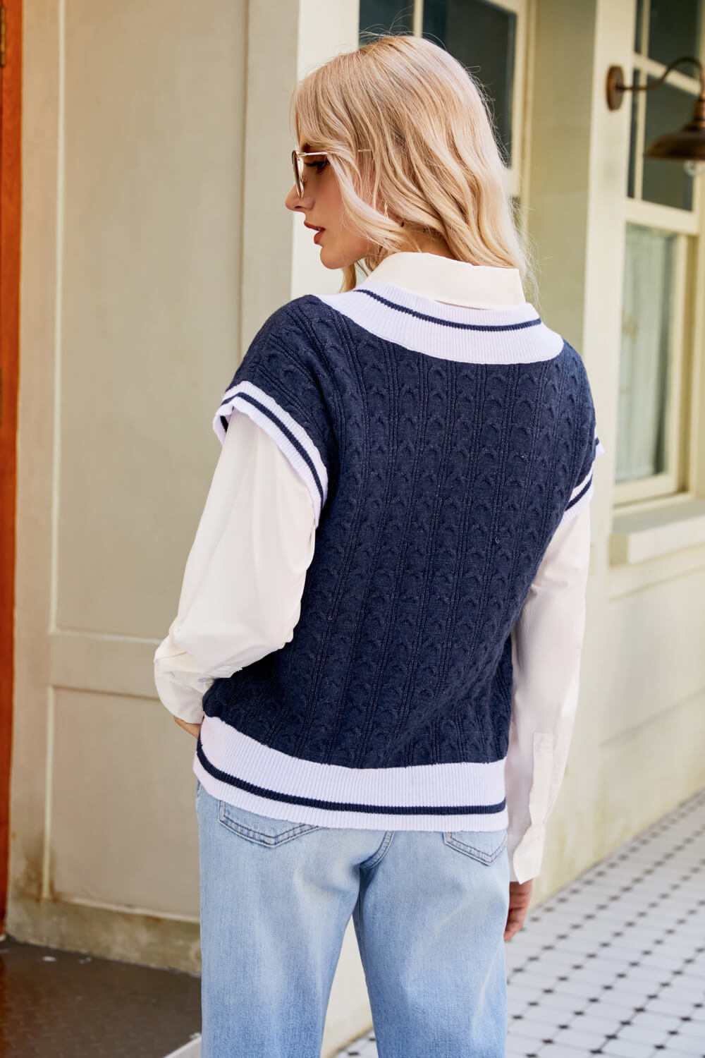 A stylish Contrast V-Neck Cap Sleeve Sweater Vest displayed outdoors, featuring a chic design with a contrast pattern and cap sleeves.